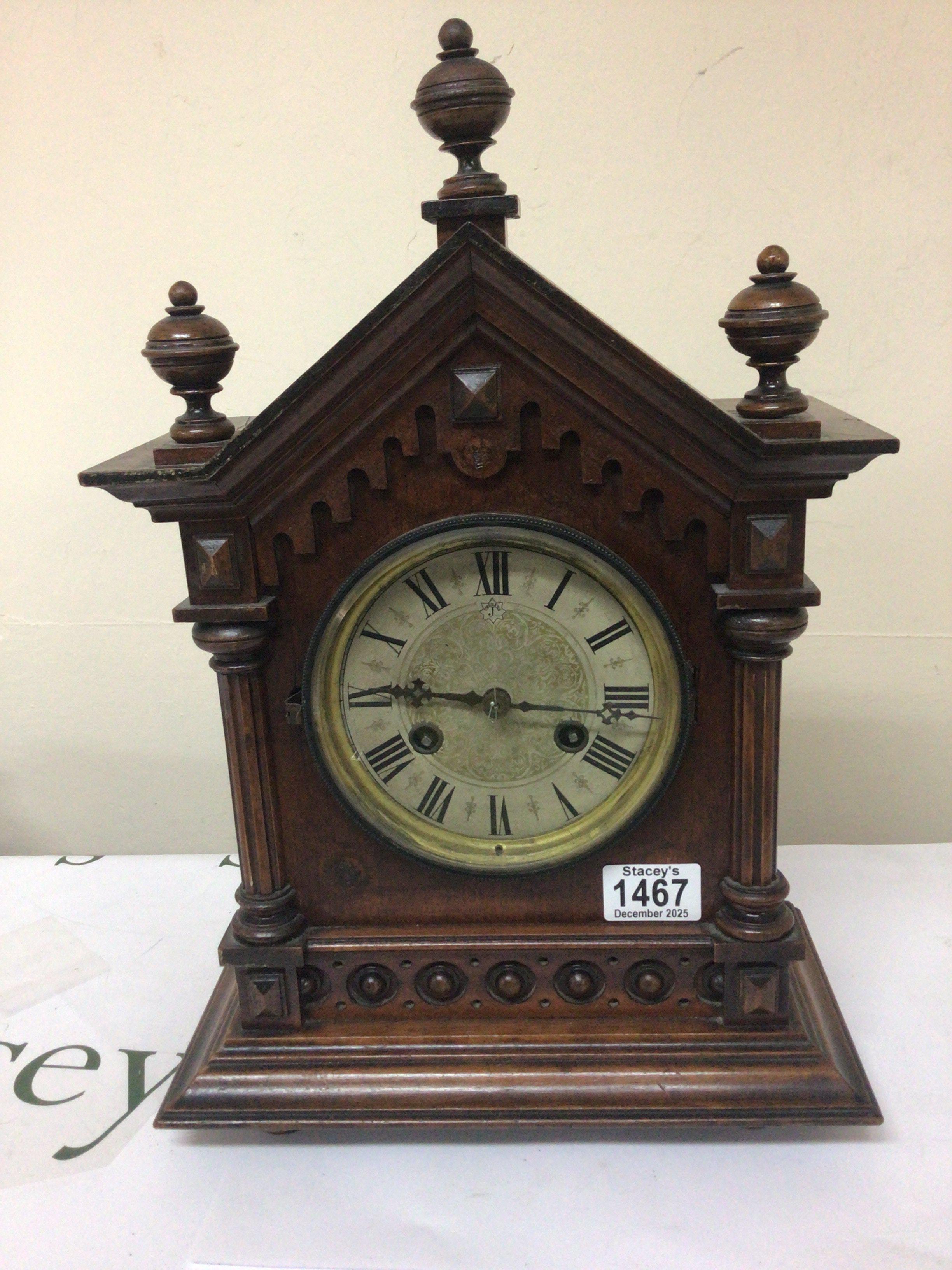 A late Victorian walnut clock with turned finials silvered dial. Height 42cm