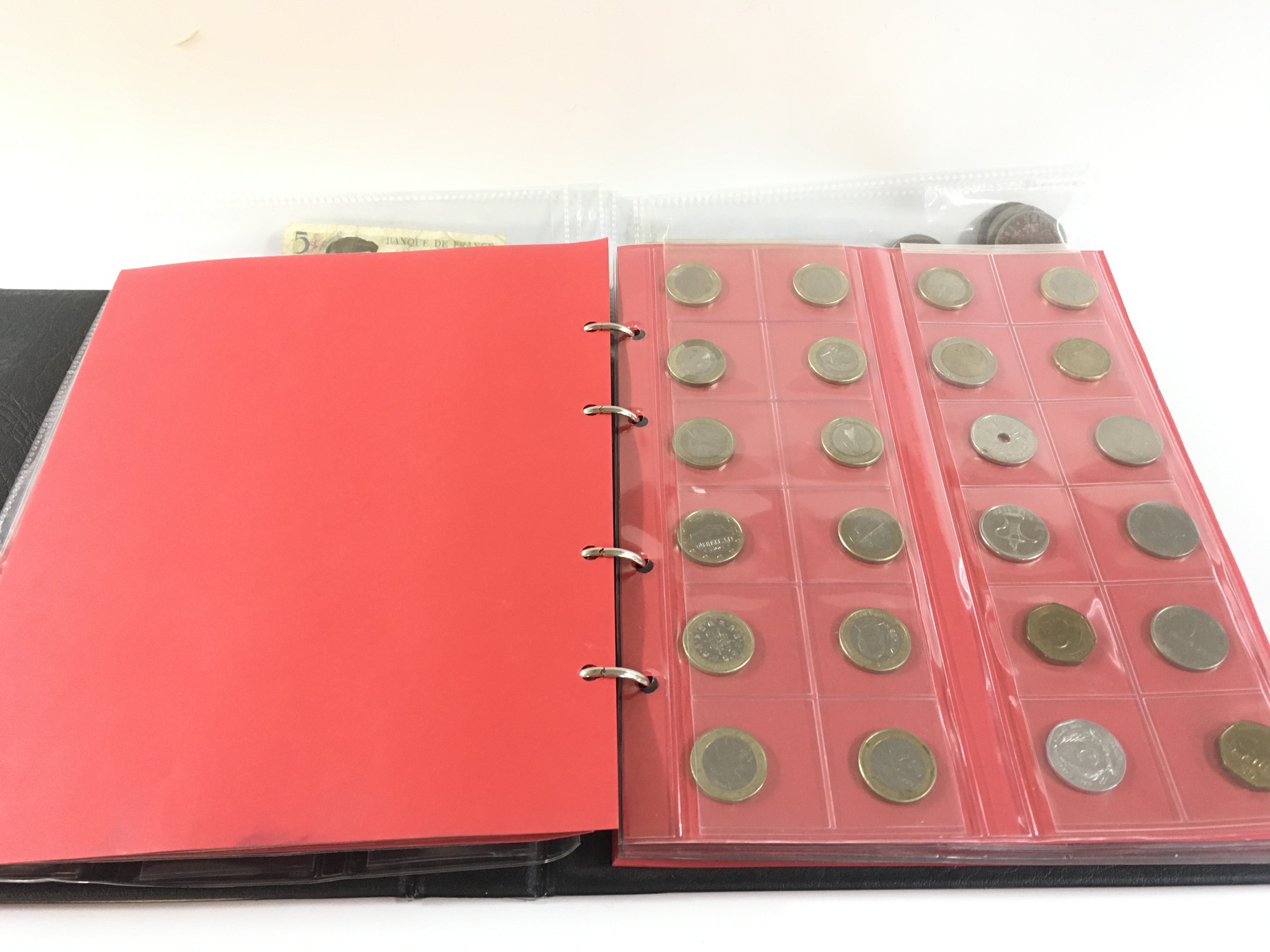 A red album containing mixed Victorian crown coinage as well as euro and other examples.