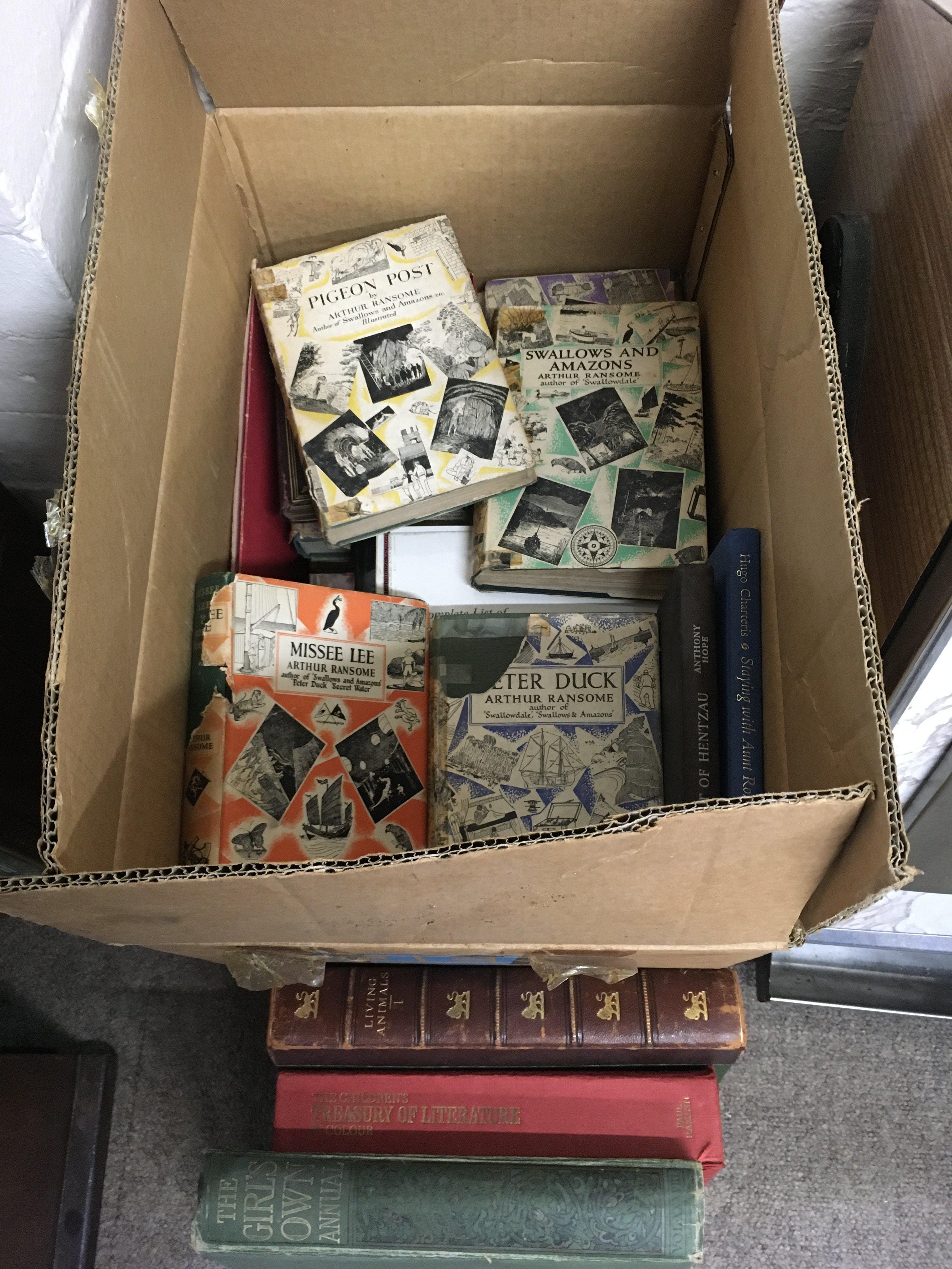 A box of books including examples by Arthur Ransome. Shipping category D.