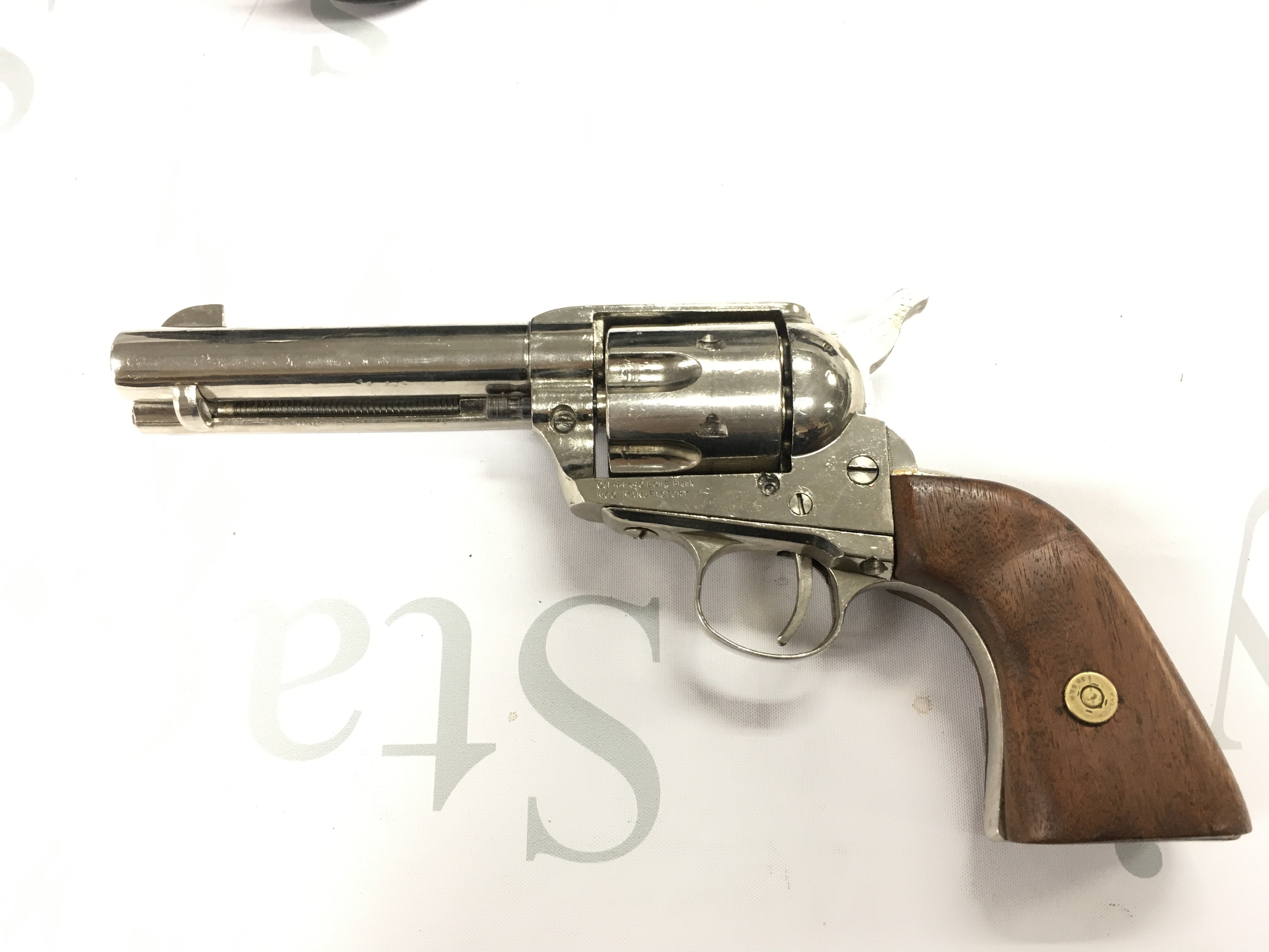 A replica blank firing MGG maker colt revolver in a leather holster