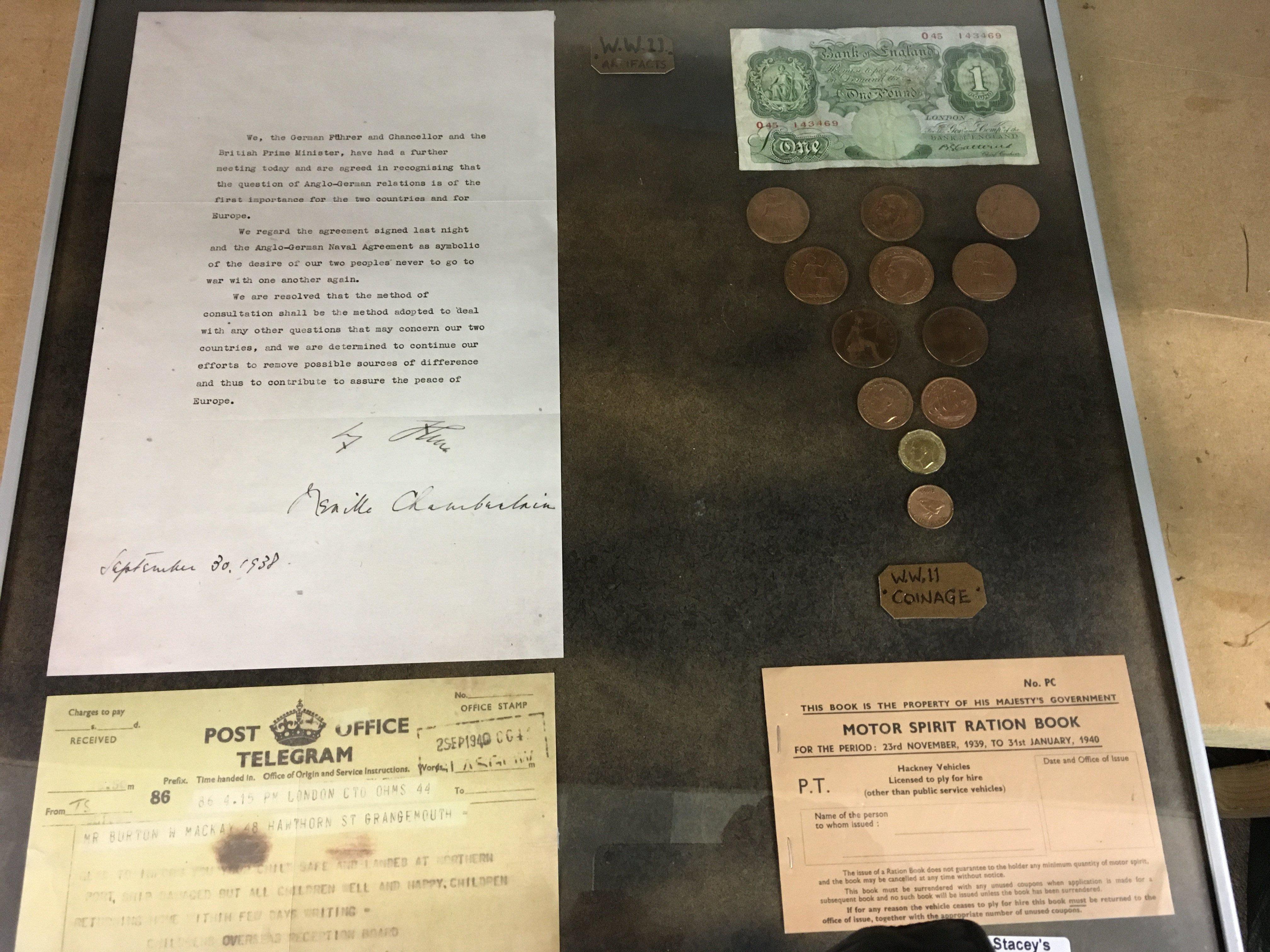 A framed collection of WW11 artefacts.