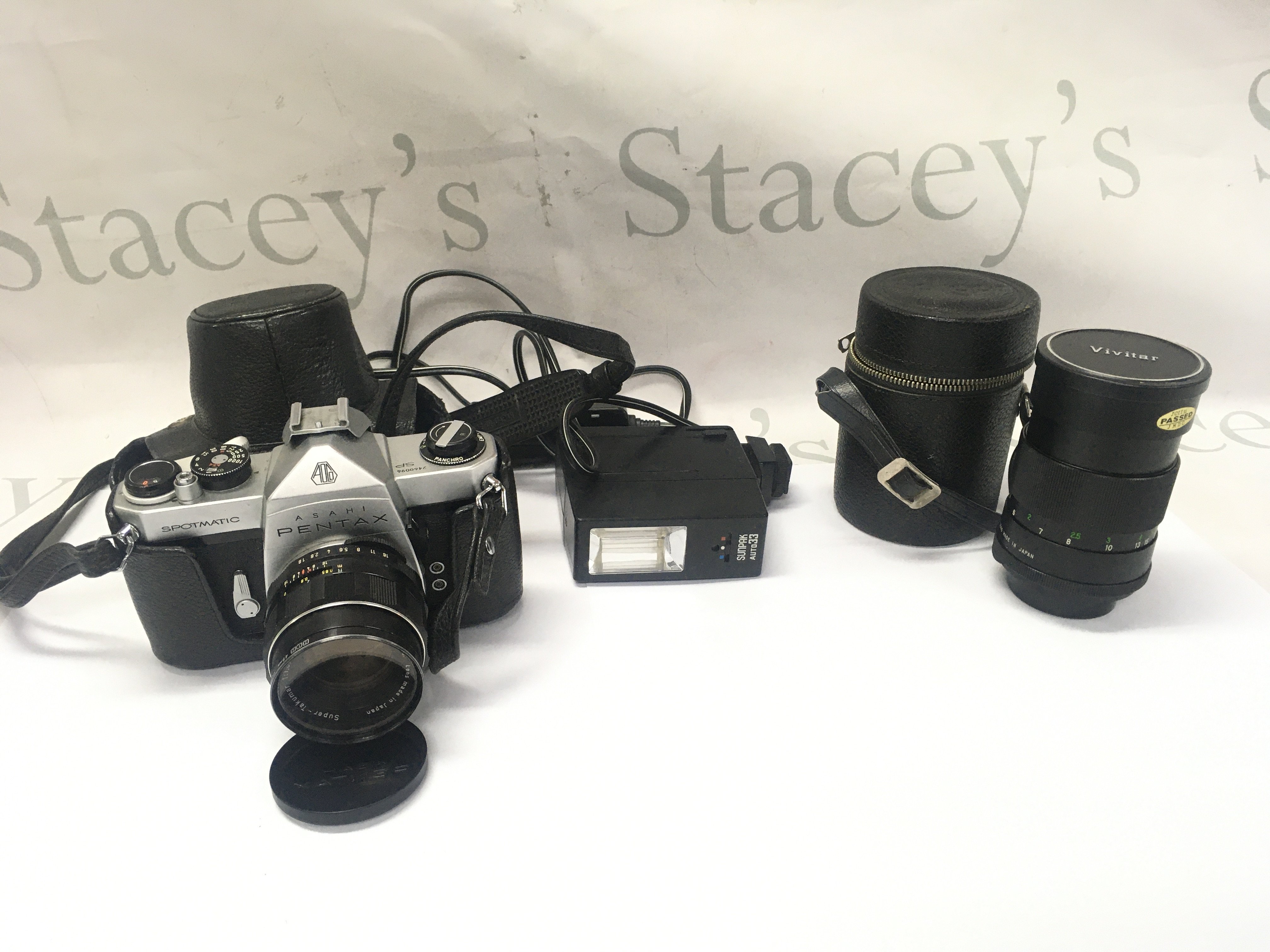 A Pentax spotmatic camera with 2 lenses and flash.
