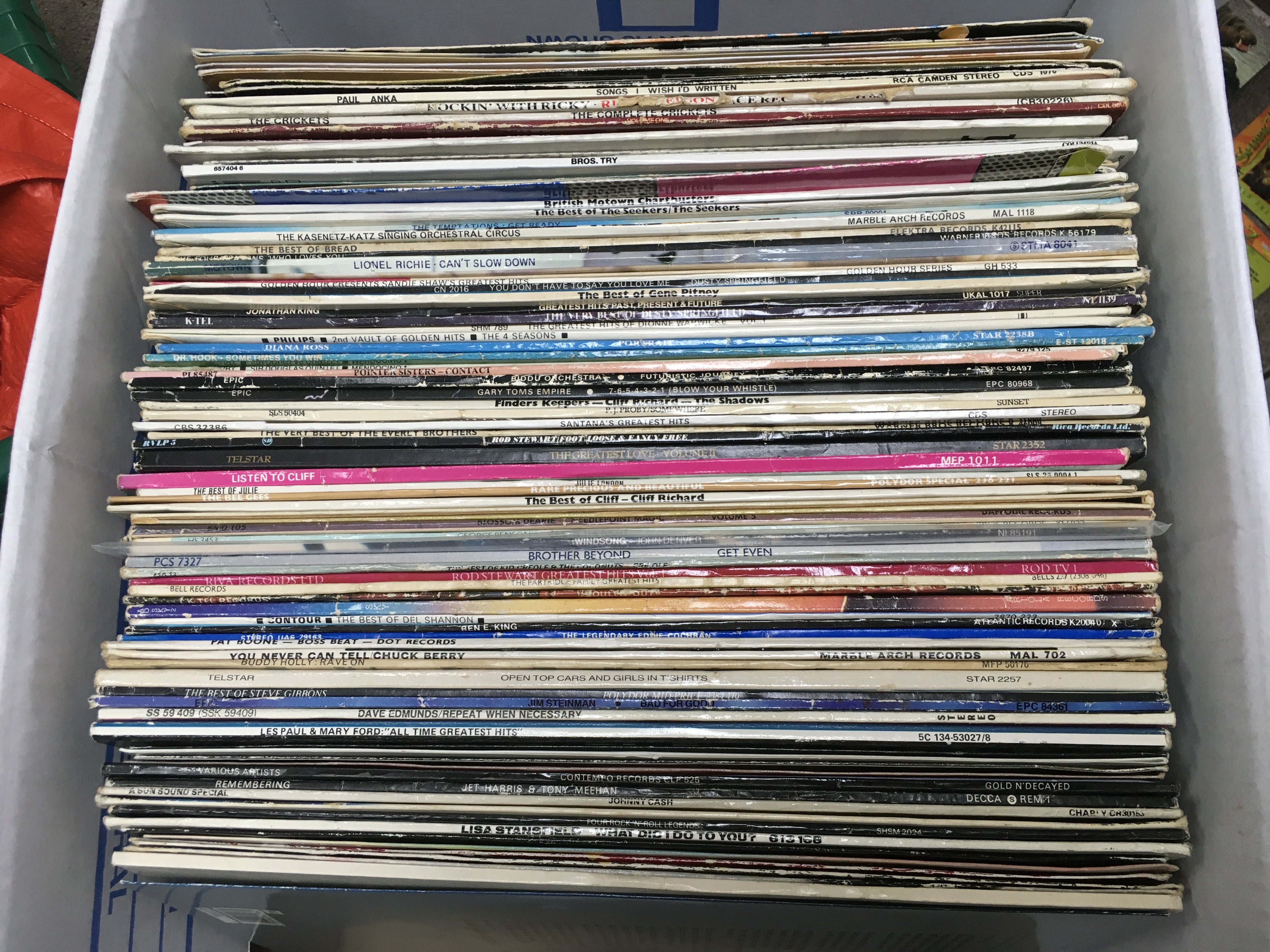 A box of LPs and 12" singles by various artists including Eddie Cochran, Santana, Chuck Berry and others. Shipping category D.