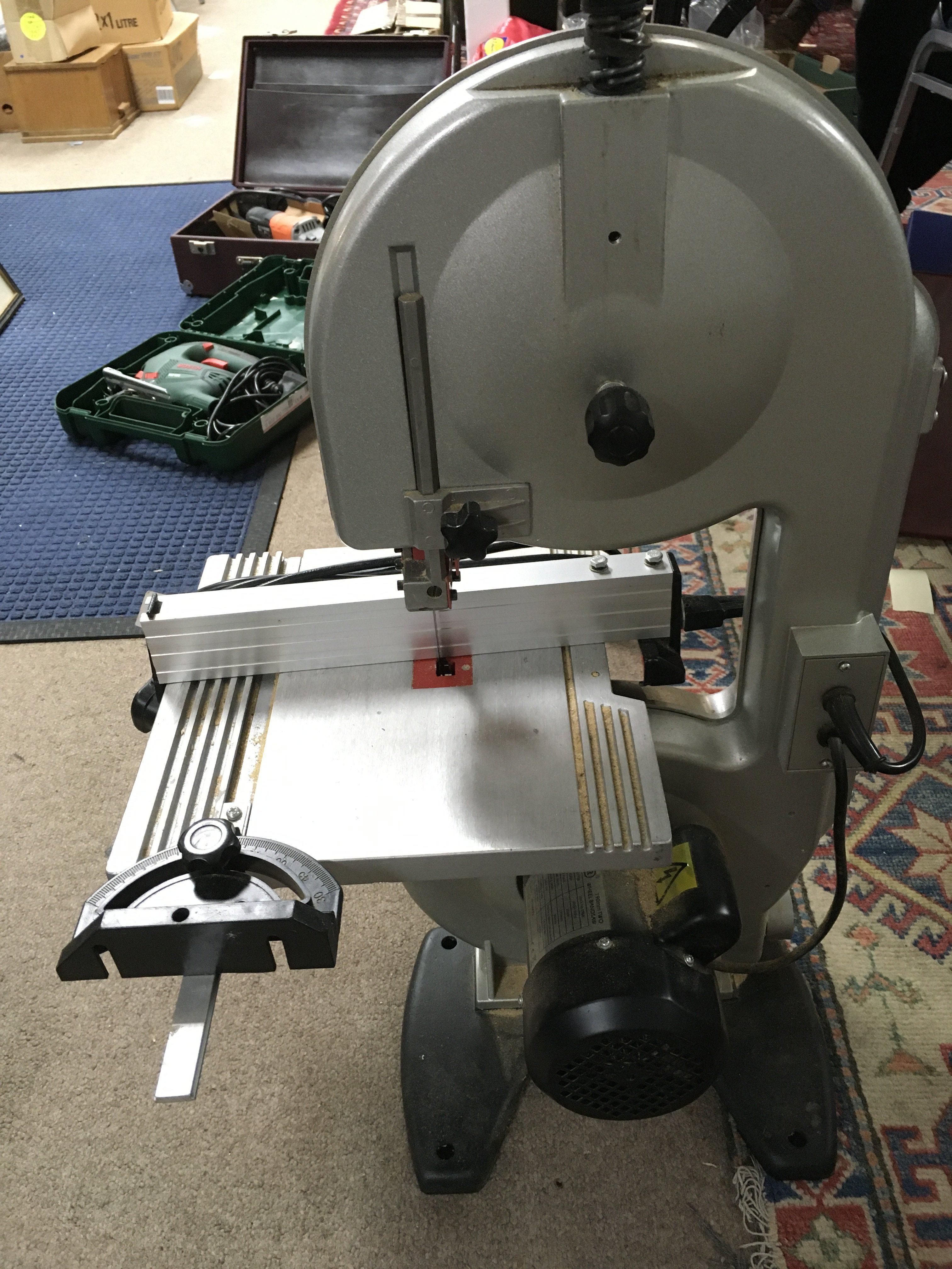 A Draper 190mm two wheel band saw serial number 11030072 with a collection of cased electrical tools including a skillsaw classic.