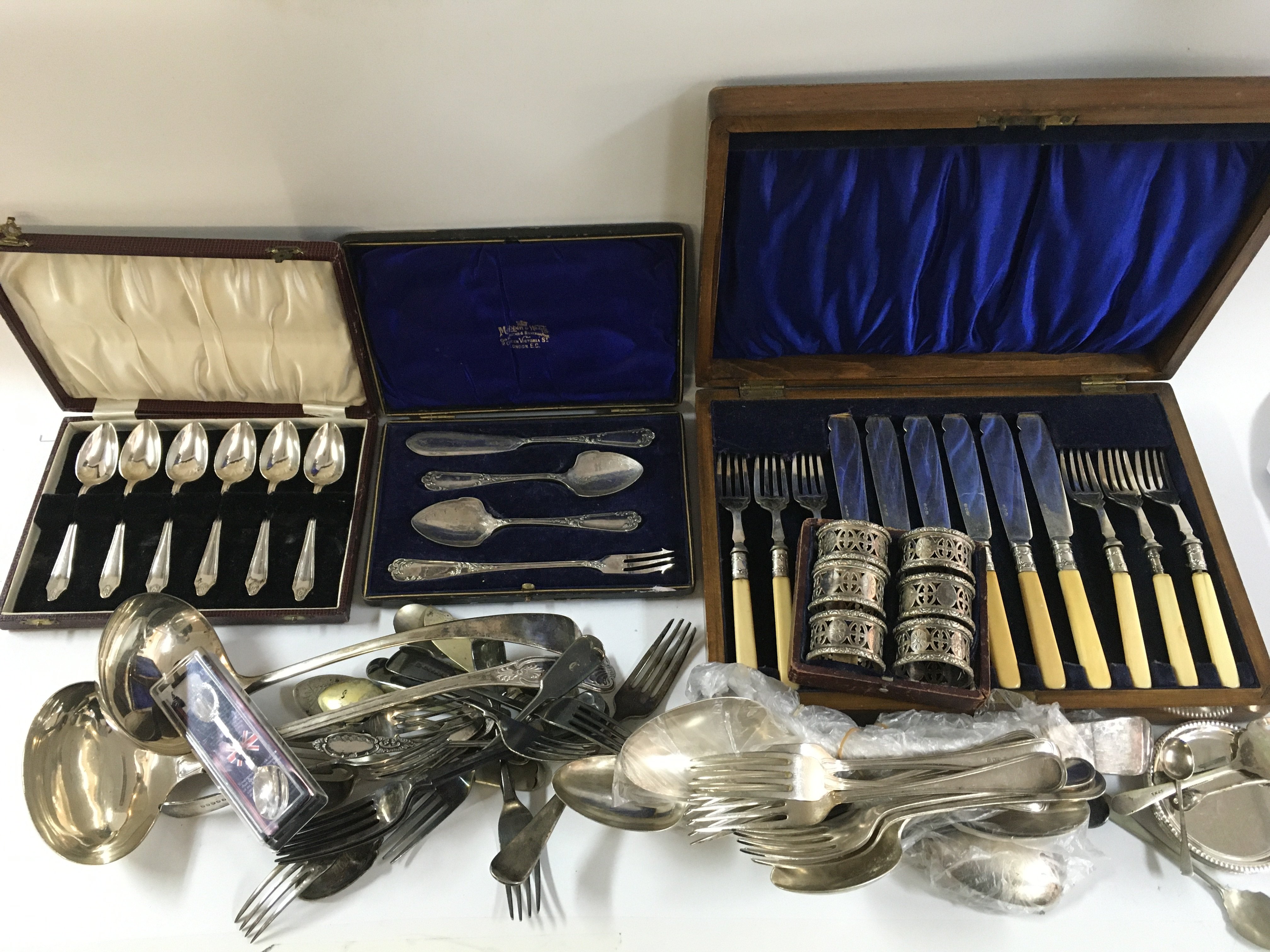 A collection of silver plated cutlery including knives, forks, napkin rings, tray etc