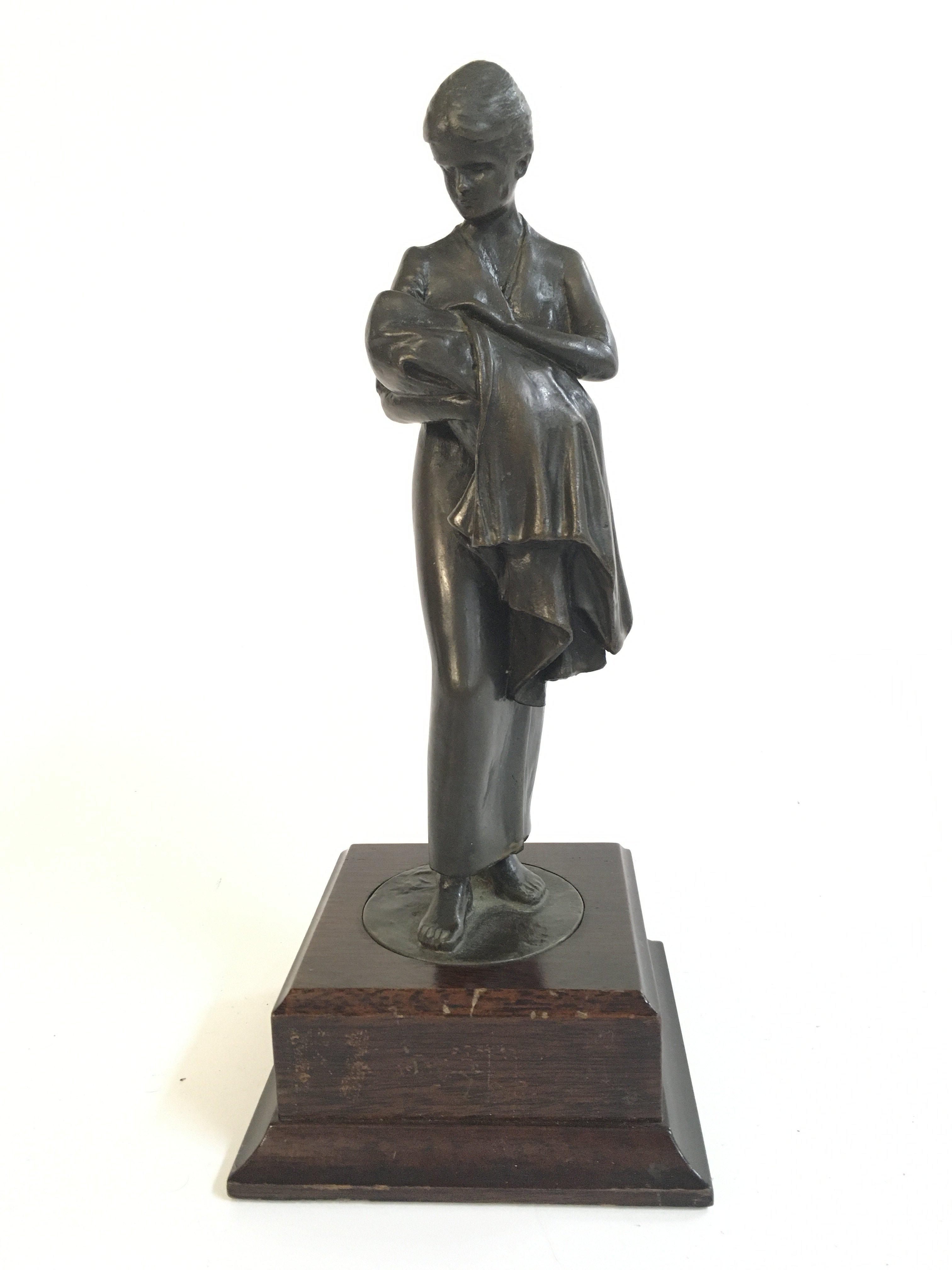 A bronze figure of a lady nursing a baby , 25cm tall. Postage category B