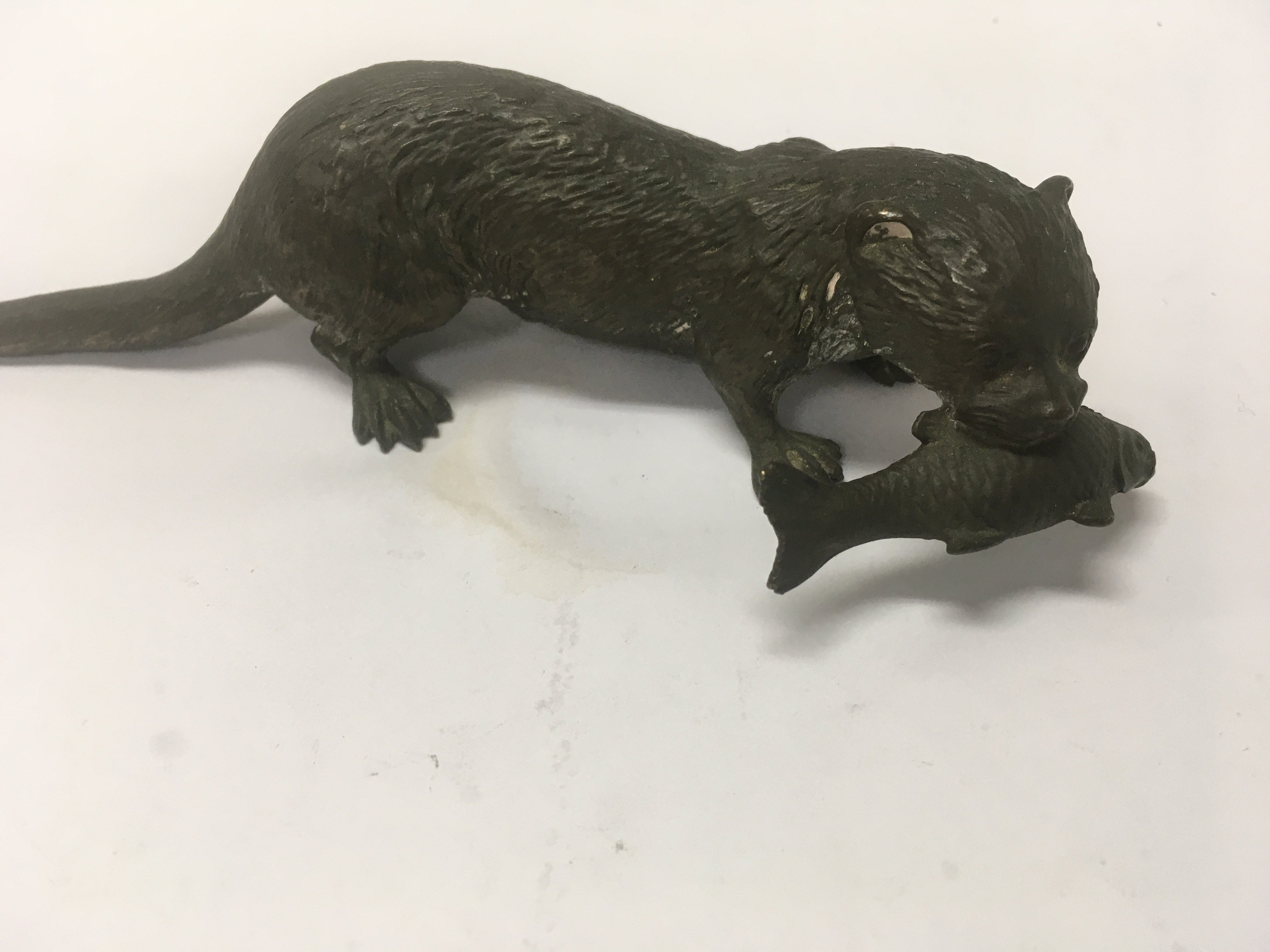 A cast bronze figure in the form of a otter with fish in mouth . 16 cm .