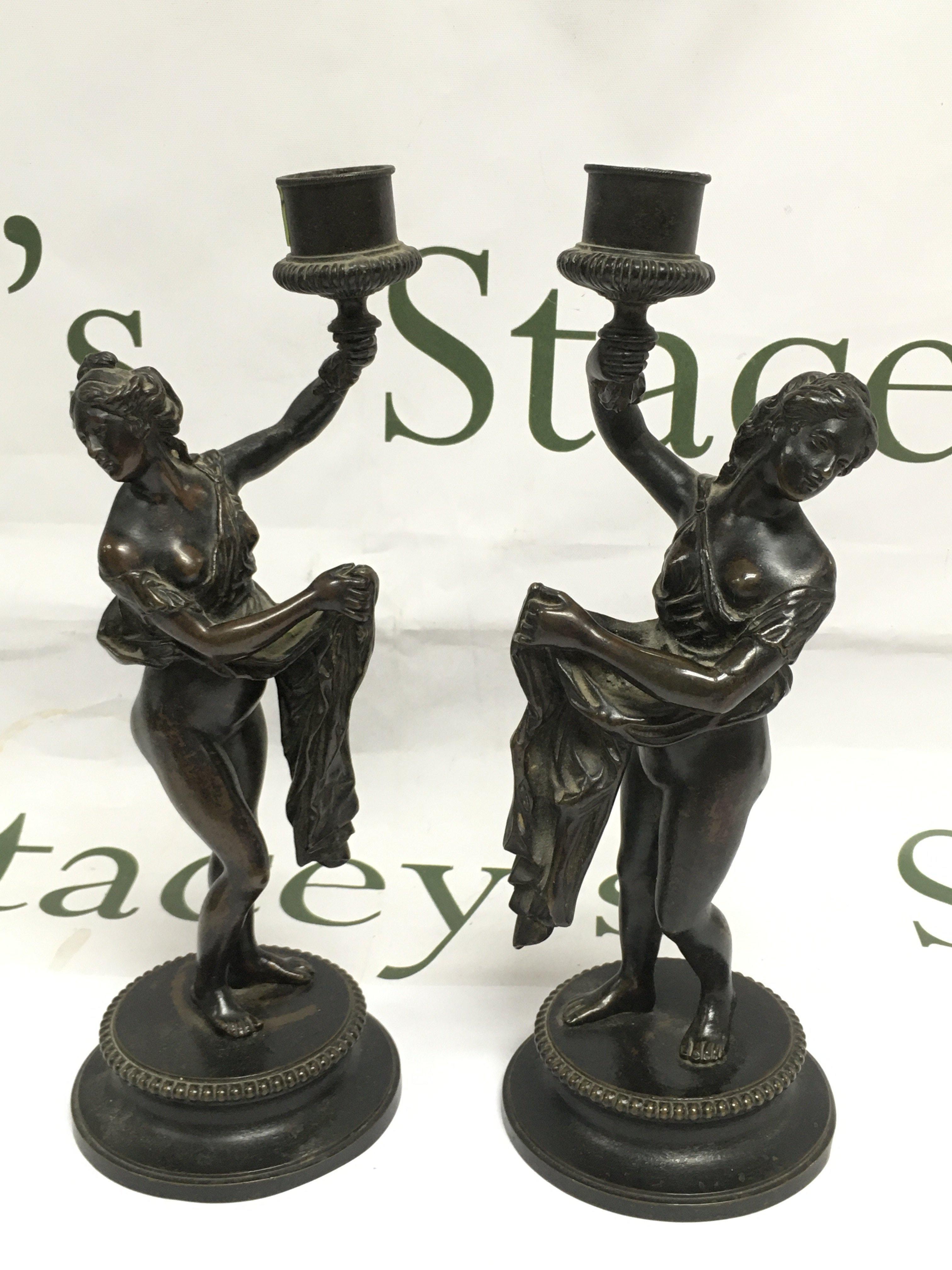 A pair of bronze figural candlesticks, approx 24cm. Shipping category B.