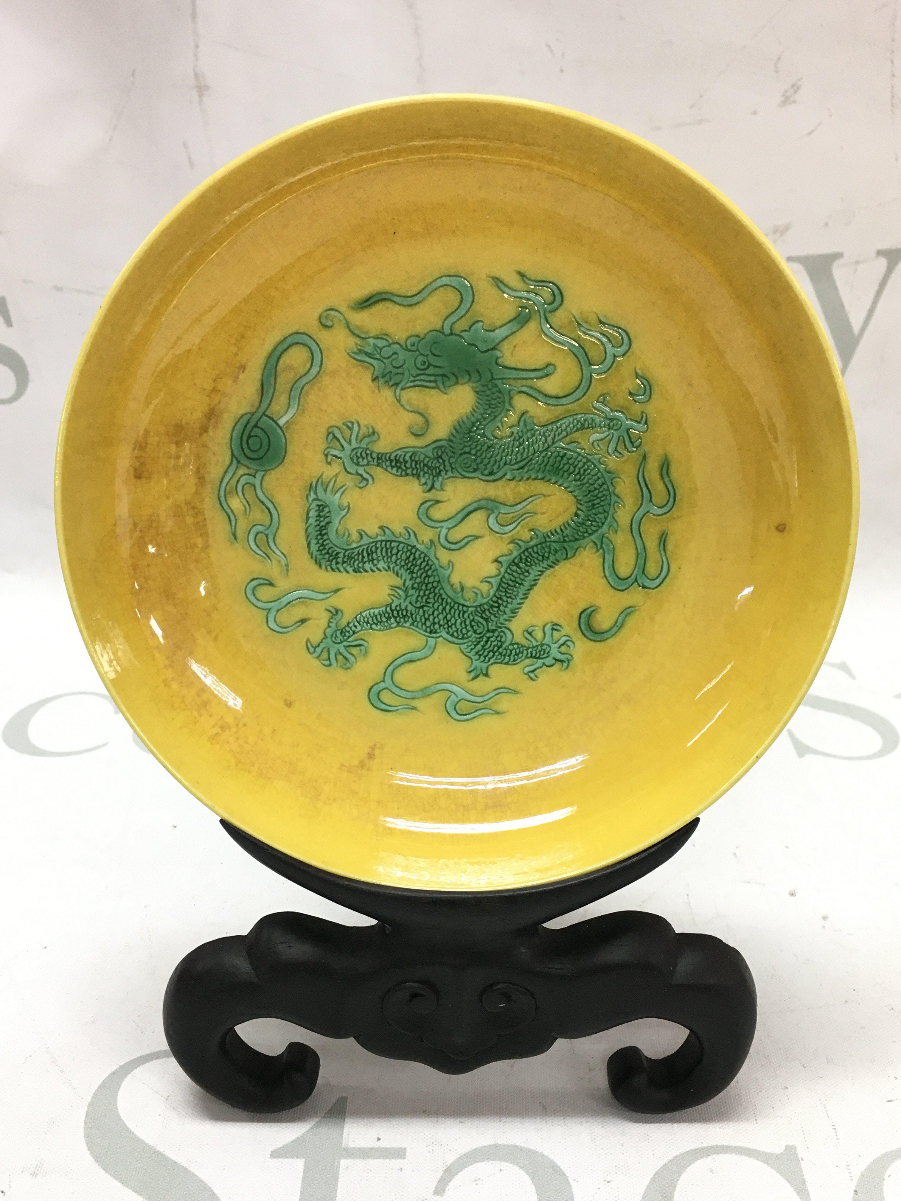A yellow glaze dragon dish with a four character mark at the base. 14cm wide. This lot cannot be posted