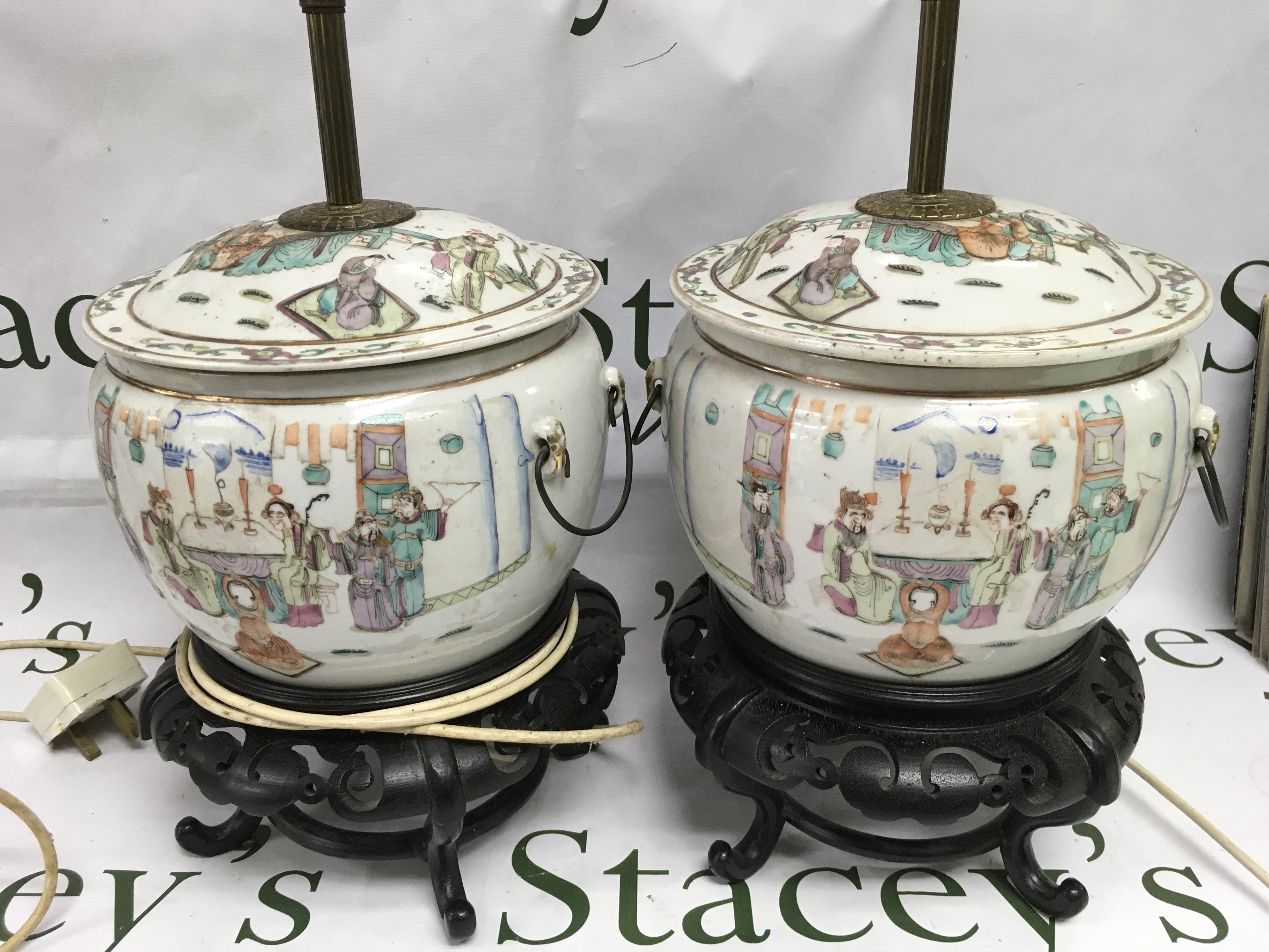 A pair of hand painted Oriental ceramic lamps raised on carved hardwood stands. Shipping category D.