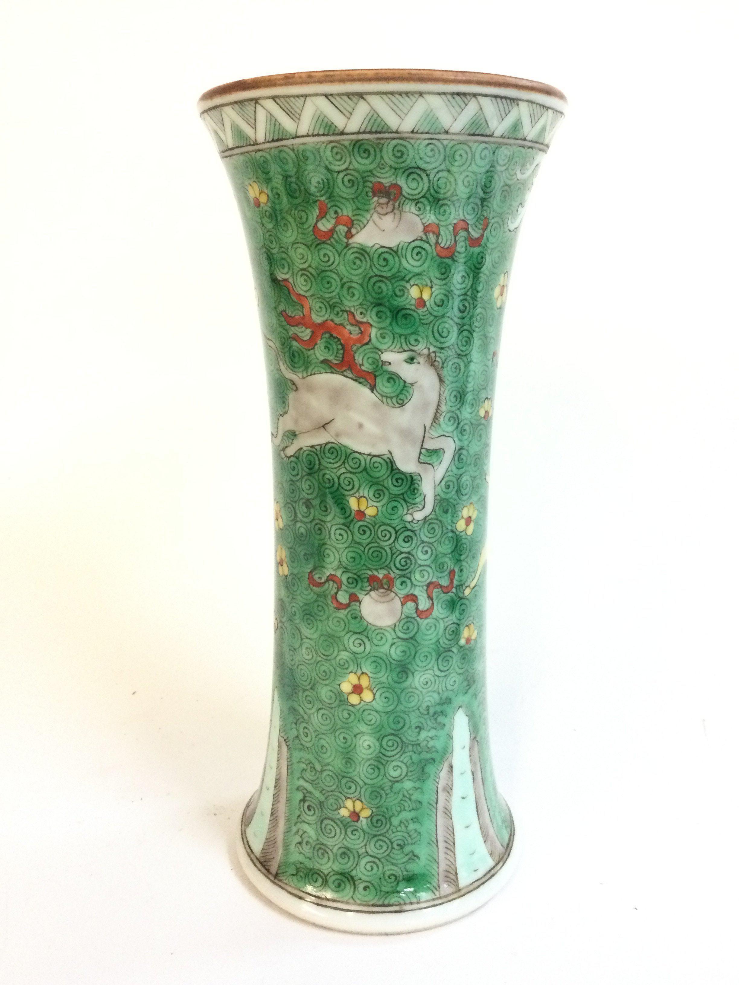 A Famille Verte Chinese vase decorated with small yellow and red flowers, depictions of a prancing horse with red ribbons. 22cm tall .No obvious large damage or restoration