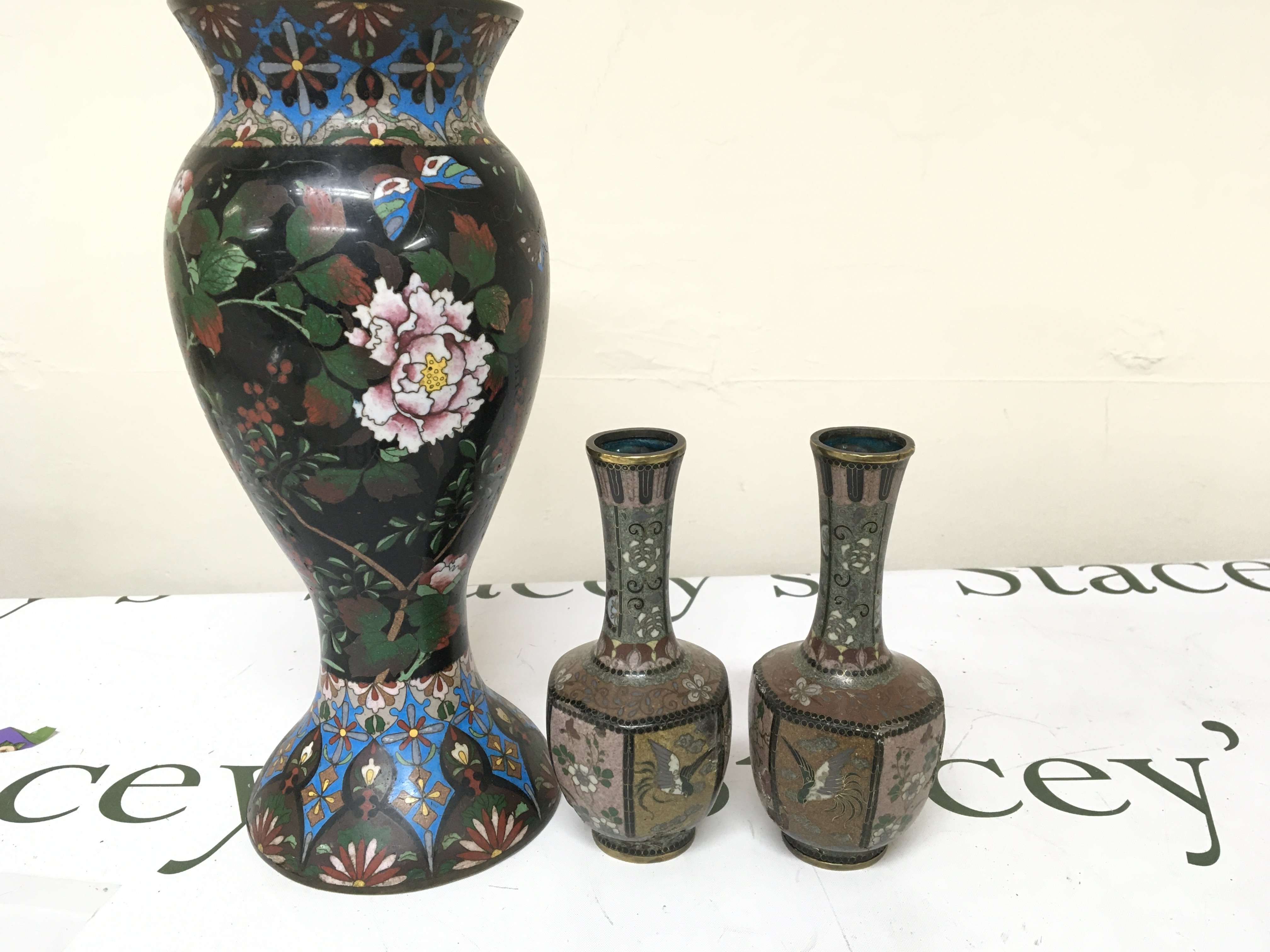 A Pair of later 19th century Cloisonne vases of octagonal shape (damaged) a large Cloisonne Vase decorated with flowers and foliage on a black ground. Height 29cm (3)