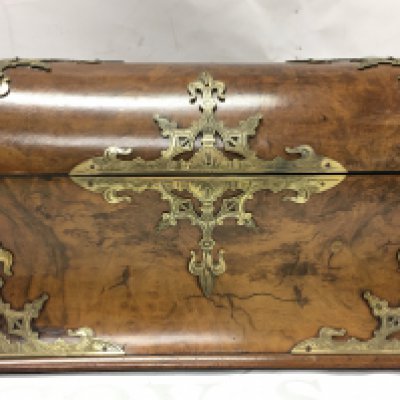 A walnut dome topped stationary box with ornate engraved brass mounts. 24cm wide 16cm tall
