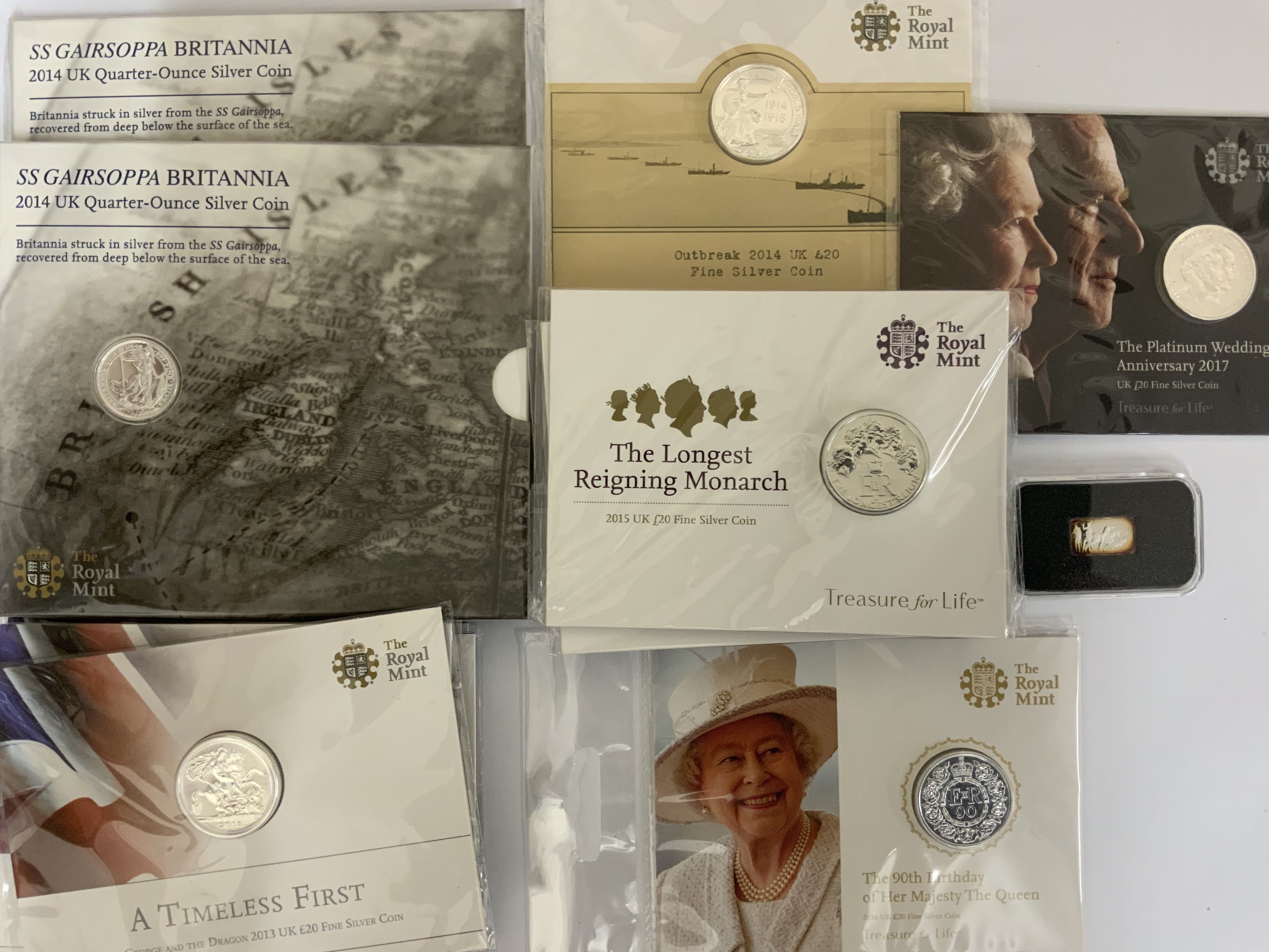 A collection of Royal mint Treasure for Life silver proof coins. To include x2 2014 SS GAIRSIPPO Brittania quater ounce coins, 5 George & The dragon 2013 &pound;20 fine silver coins, 90th Birthday of Her Majesty the Queen 2016 &pound;20 fine silver coin, 5 Longest Reigning Monarch 2015 &pound;20 fine silver coins, Platinum Wedding Anniversary 2017 &pound;20 fine silver coins, 1 Outbreak 2014 &pound;20 fine silver coin, small 1g silver ingot. (15)