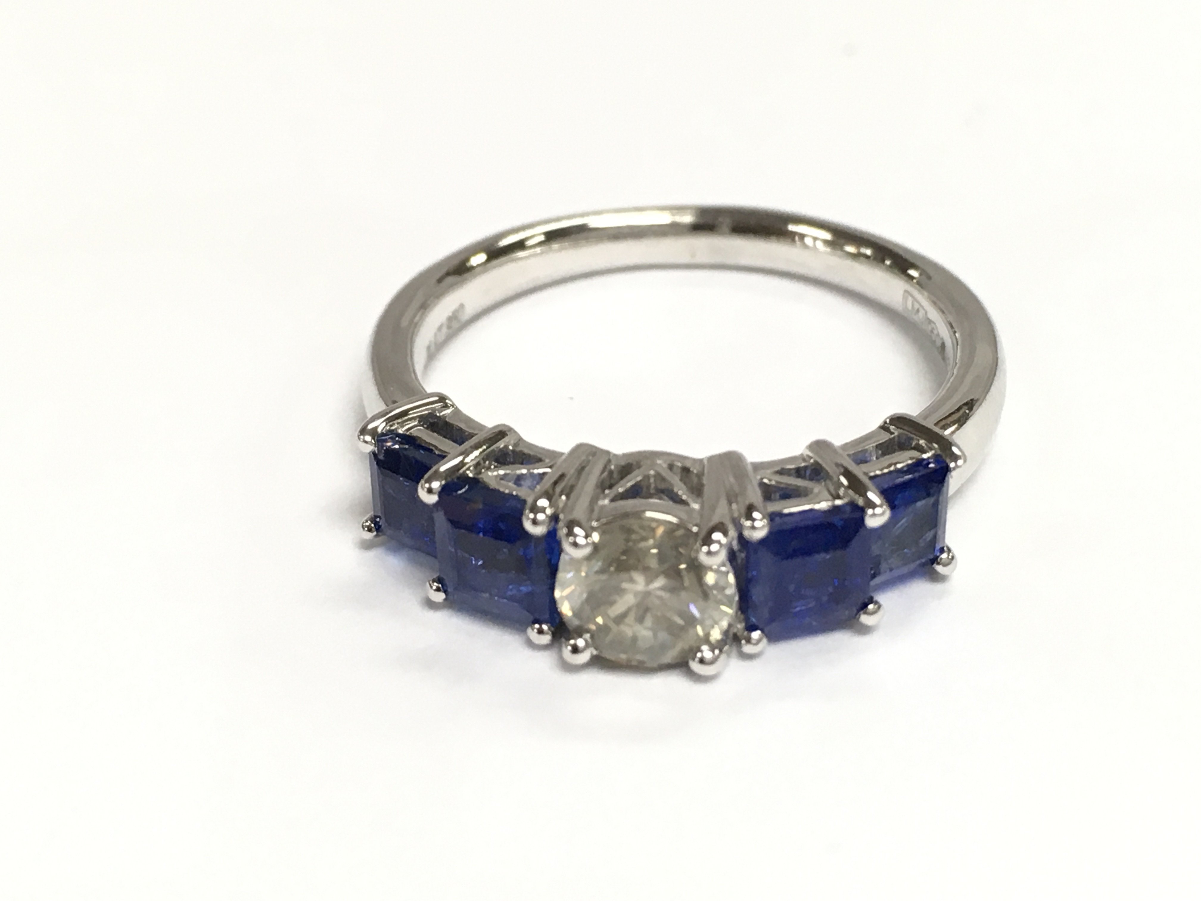 A platinum 5 stone ring set with central diamond flanked by Princess cut sapphires. Diamonds 0.53ct and sapphires 1.45ct. Size N