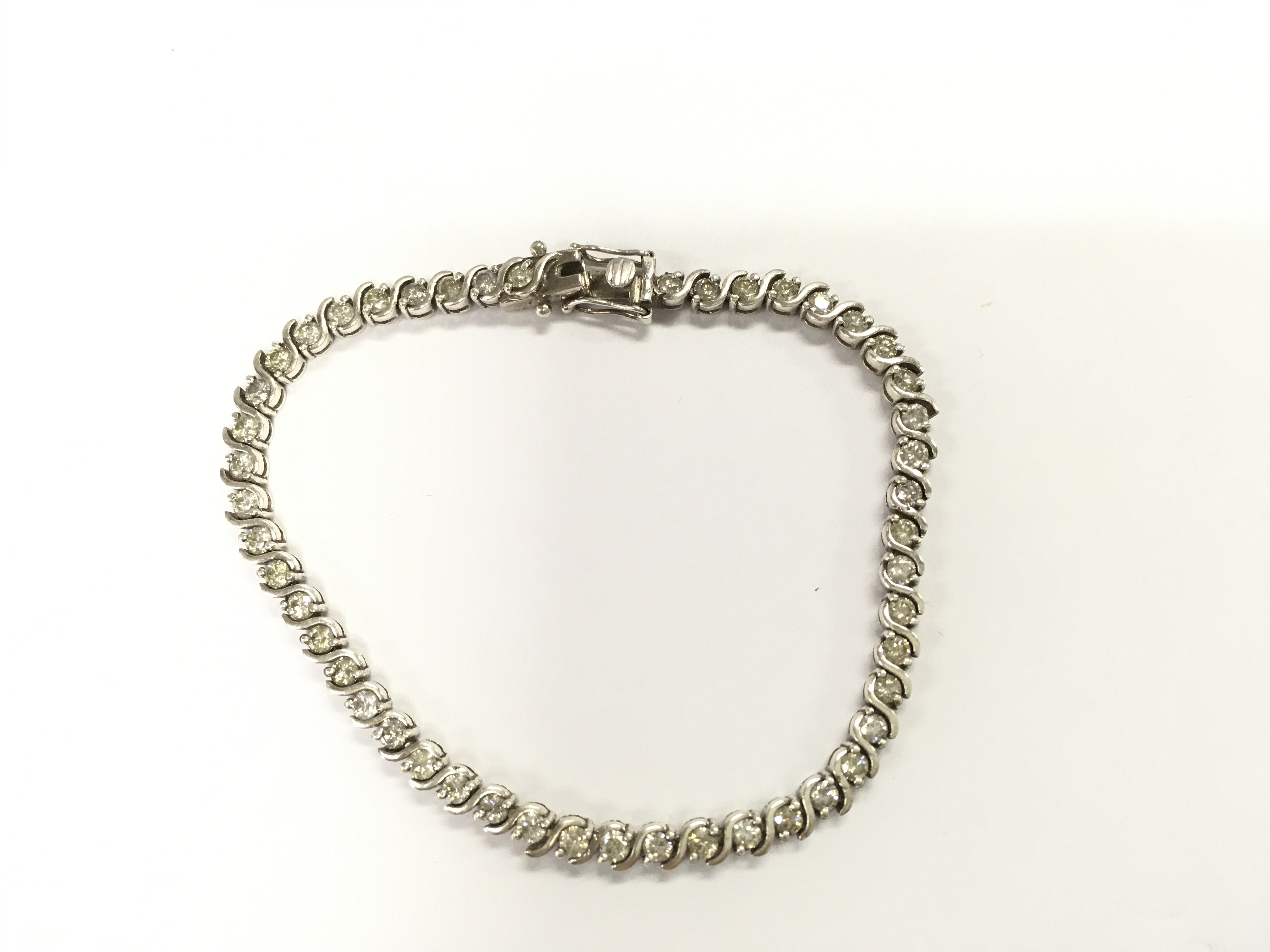 A silver line bracelet set with diamonds with twist style links. Approximately 6.50ct.