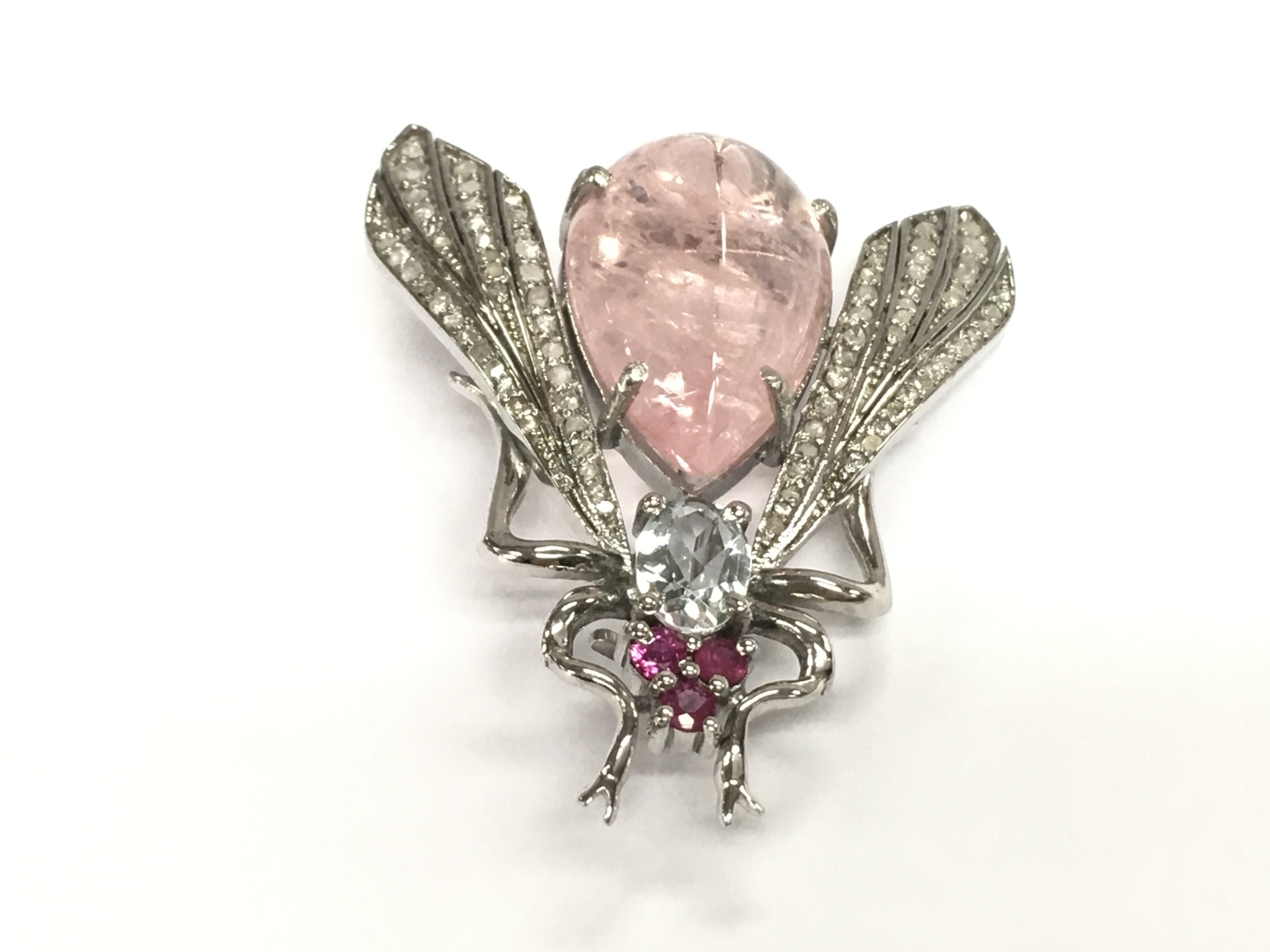 A silver fly brooch / pendant set with pear shaped pink beryl an oval aquamarine rubies and diamonds. Aquamarines 12.10ct and diamonds 0.50ct some of the very small diamonds missing.