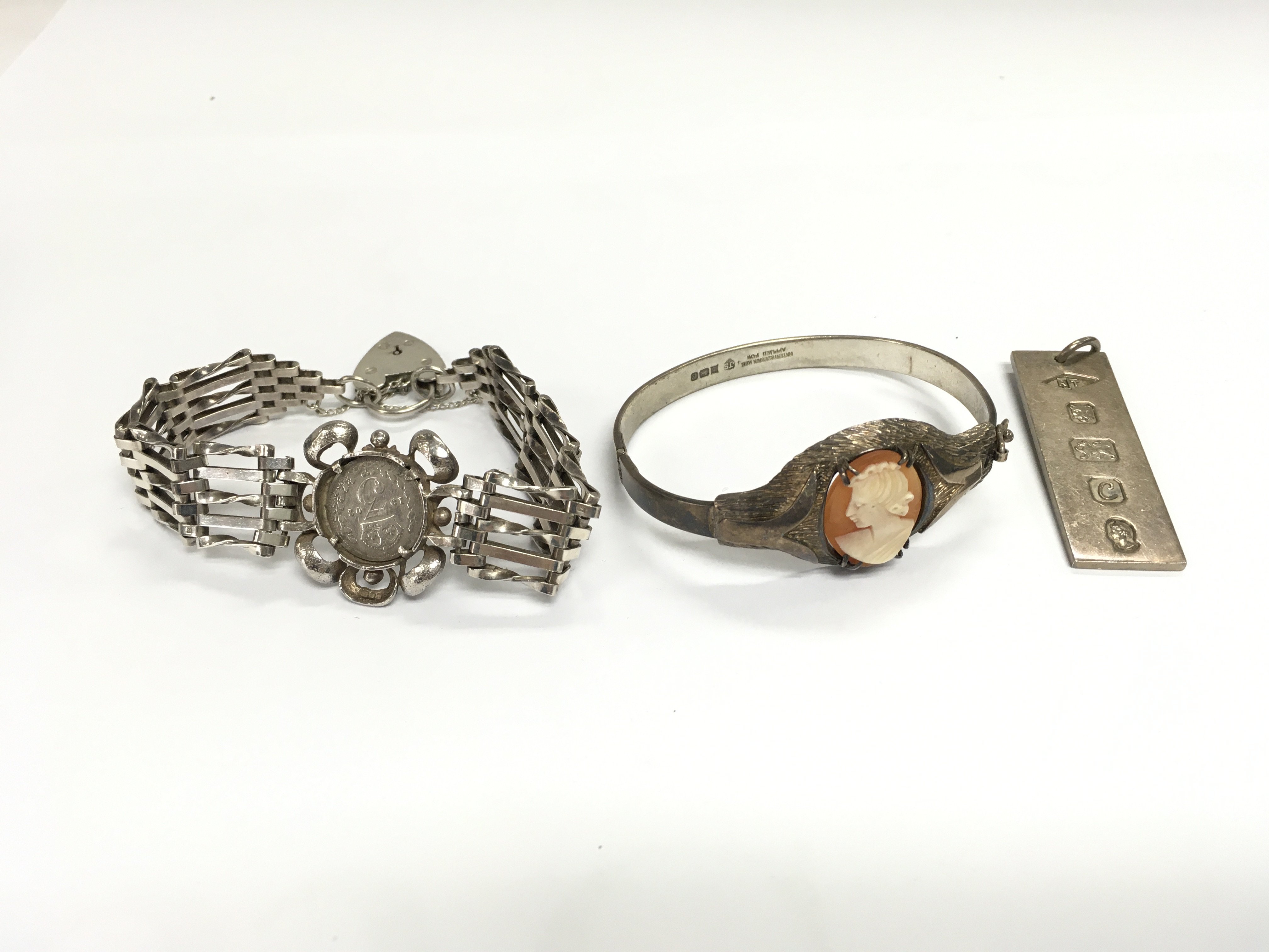 A silver cameo bangle a silver gate bracelet and a silver ingot. Total weight 66.46g