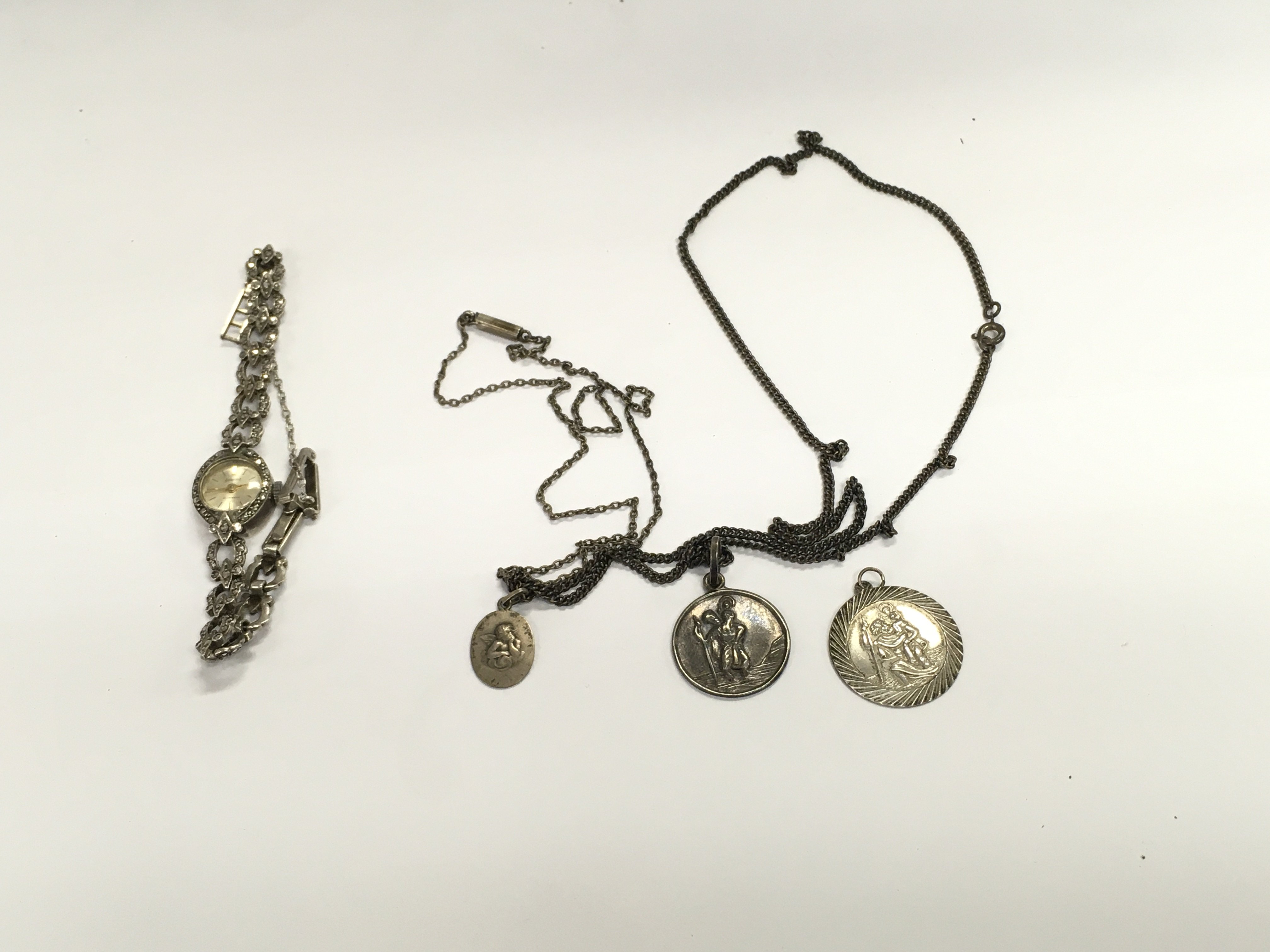 A silver ladies vintage watches and three silver st Christopher. Postage B