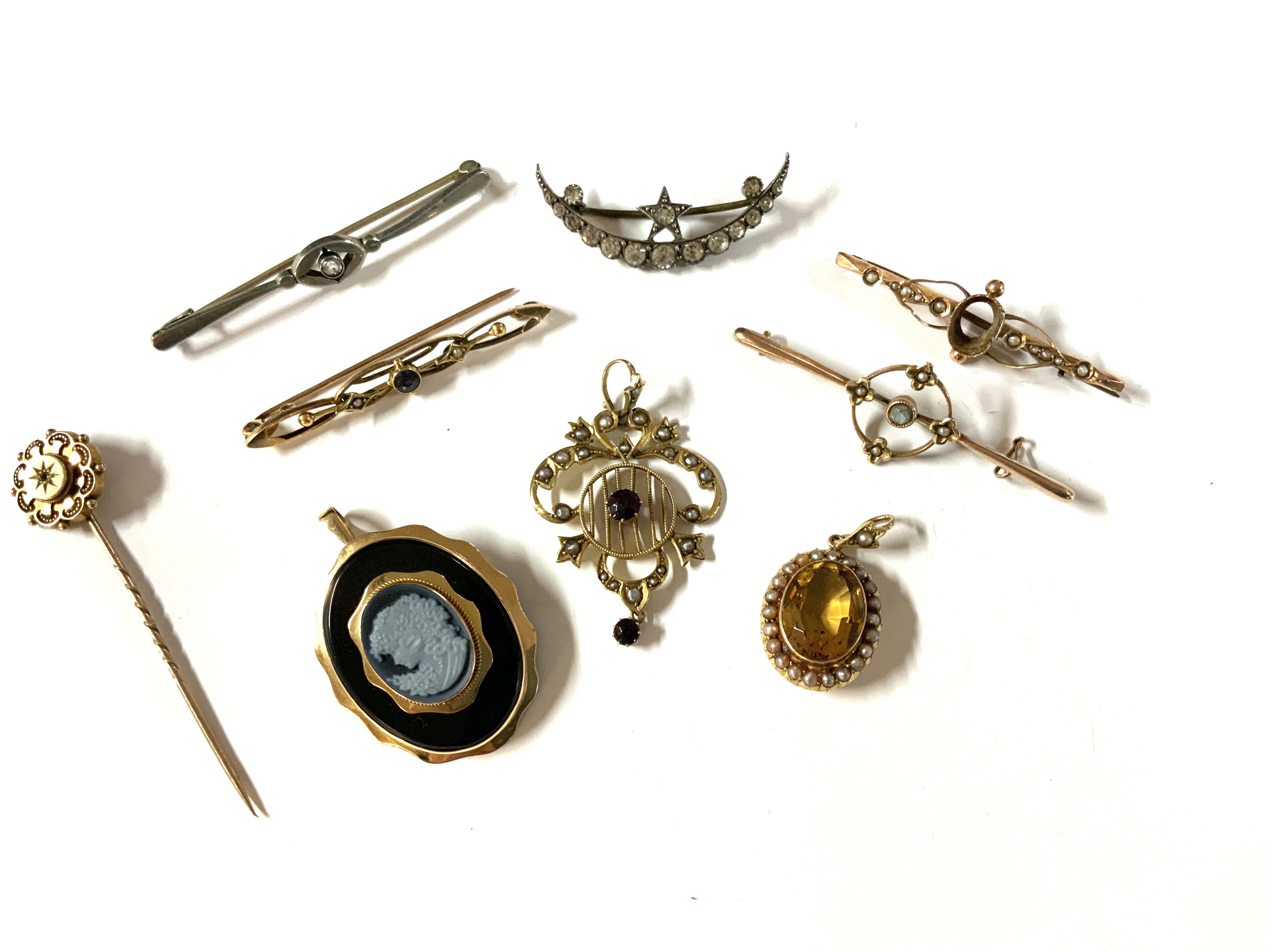 A small collection of Edwardian and later gold and silver brooches / pins / pendants. Total weight 21g. (A)