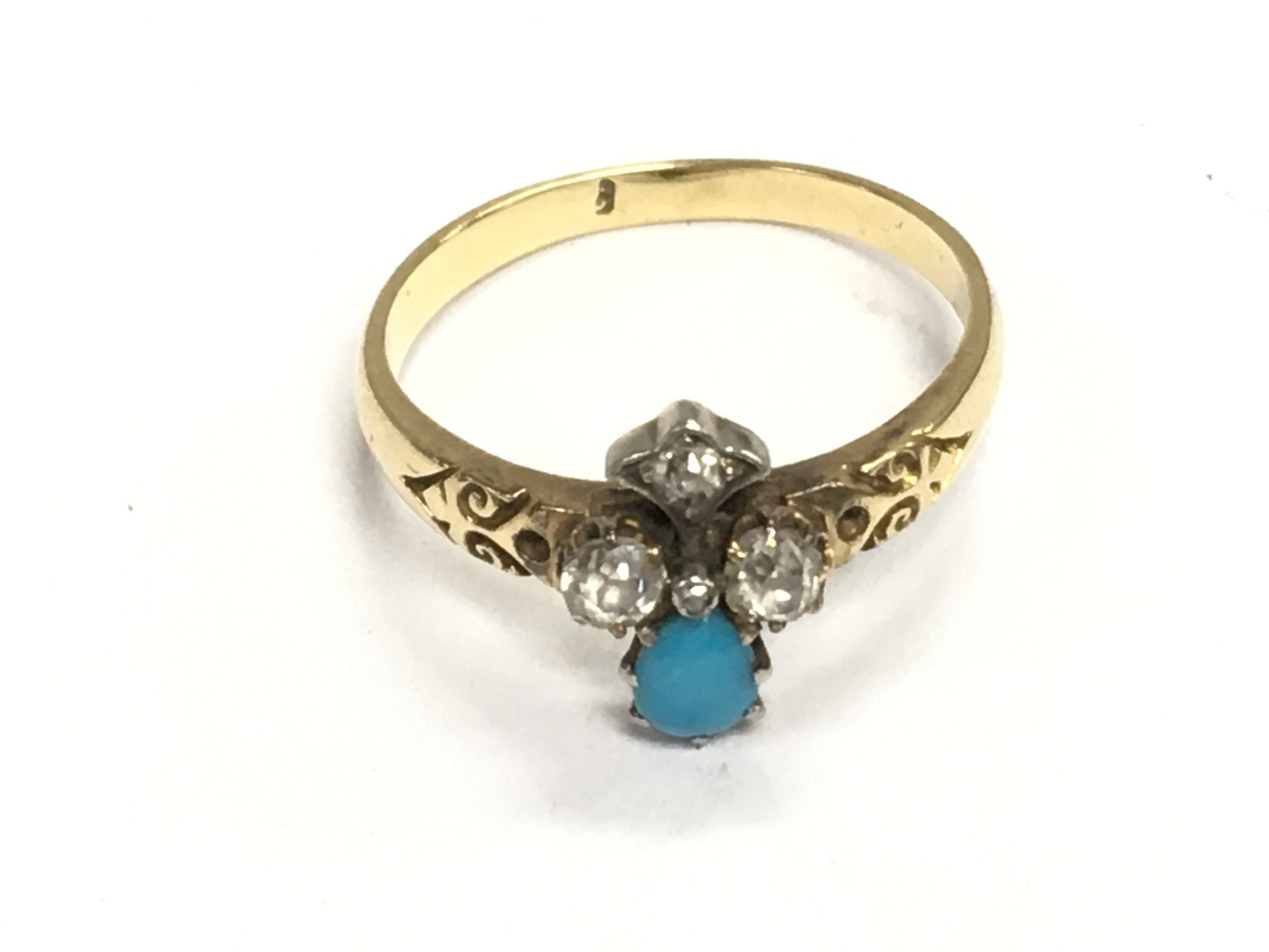 An unmarked gold ring set with turquoise and diamonds. Size P and 3.40g