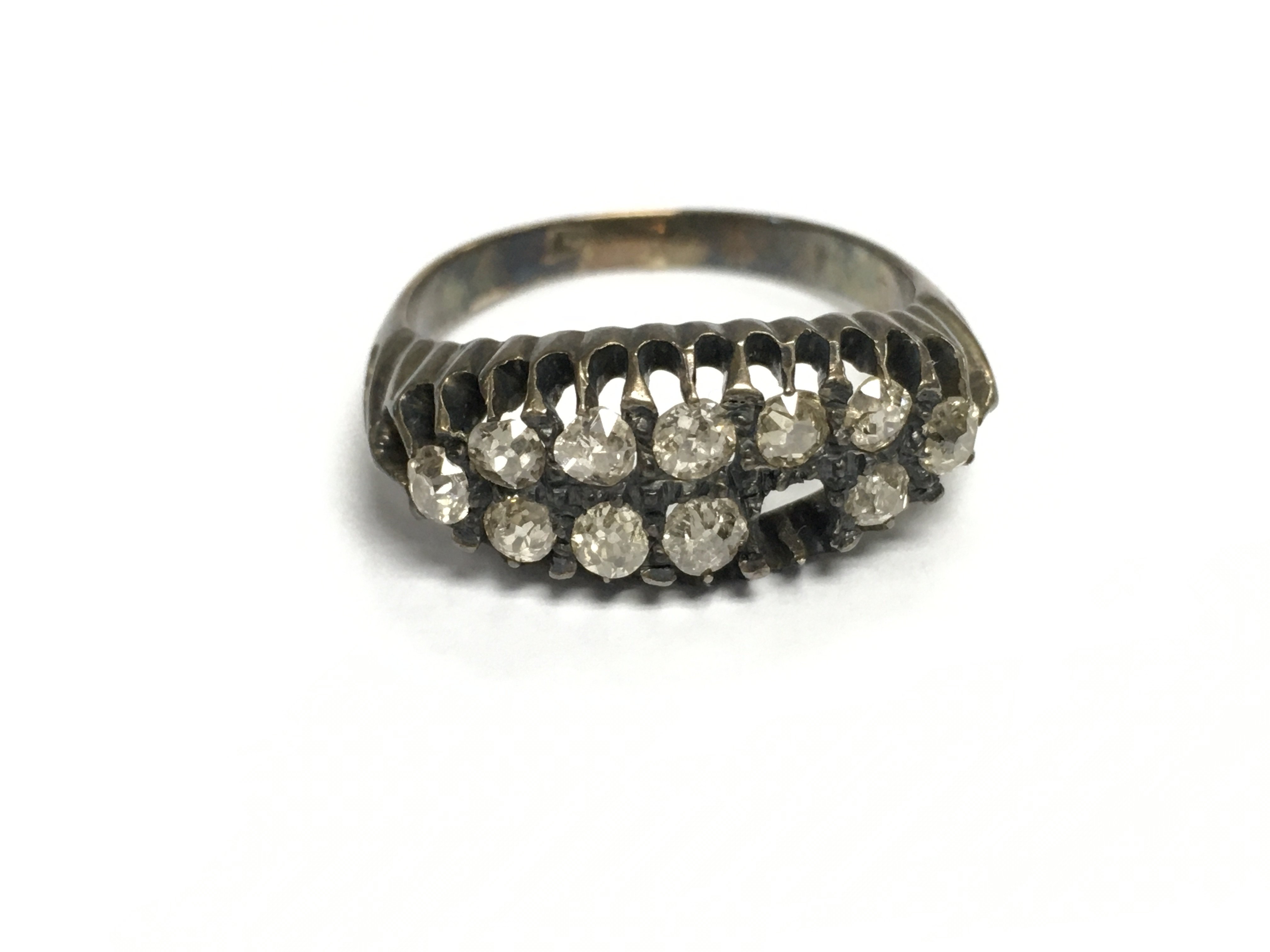 An unmarked gold diamond cluster ring with approximately 0.50ct diamonds. One stone missing. Size R and 4.35g