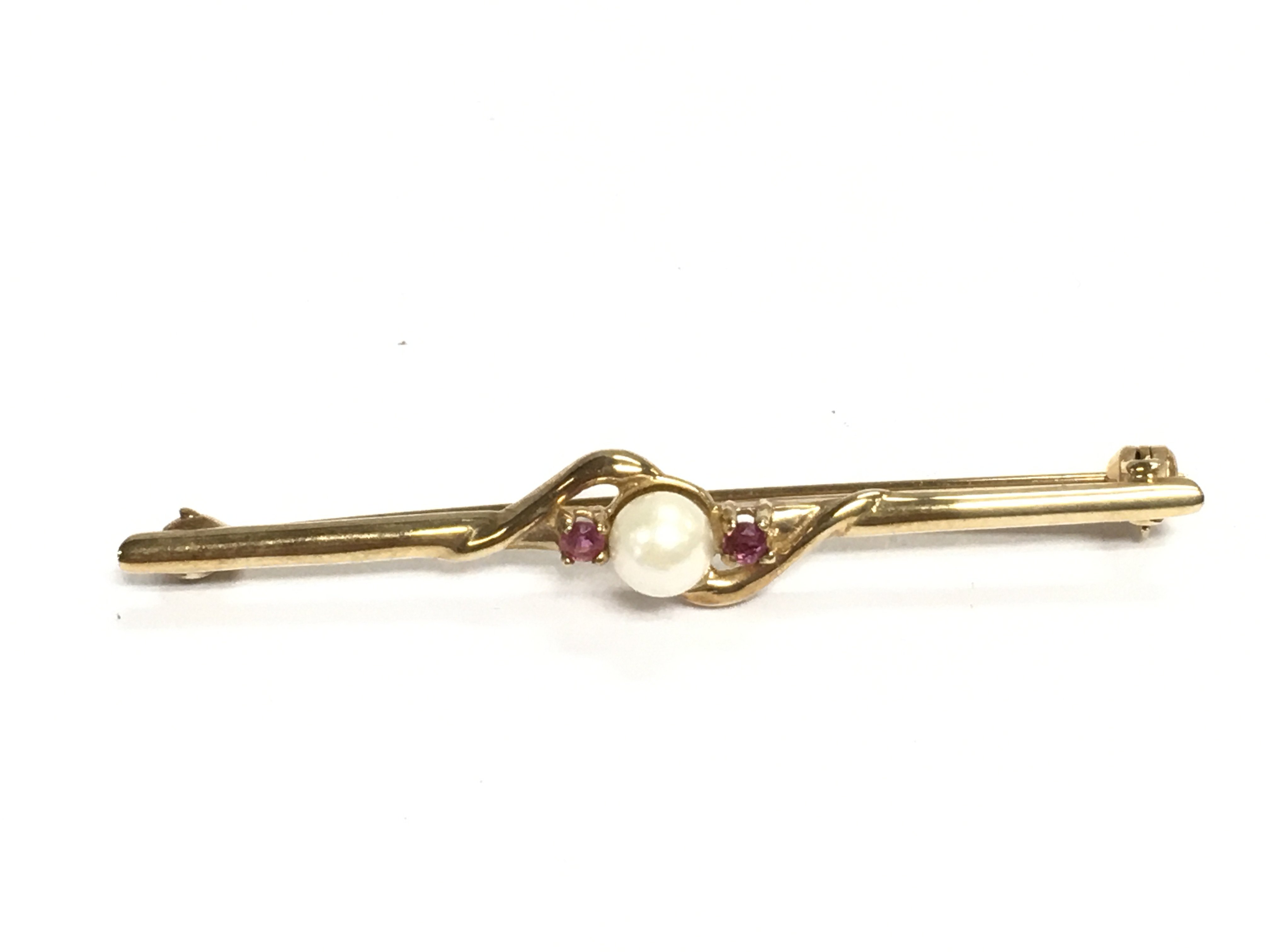 A 9ct pearl and ruby stick pin / brooch. 2.30g