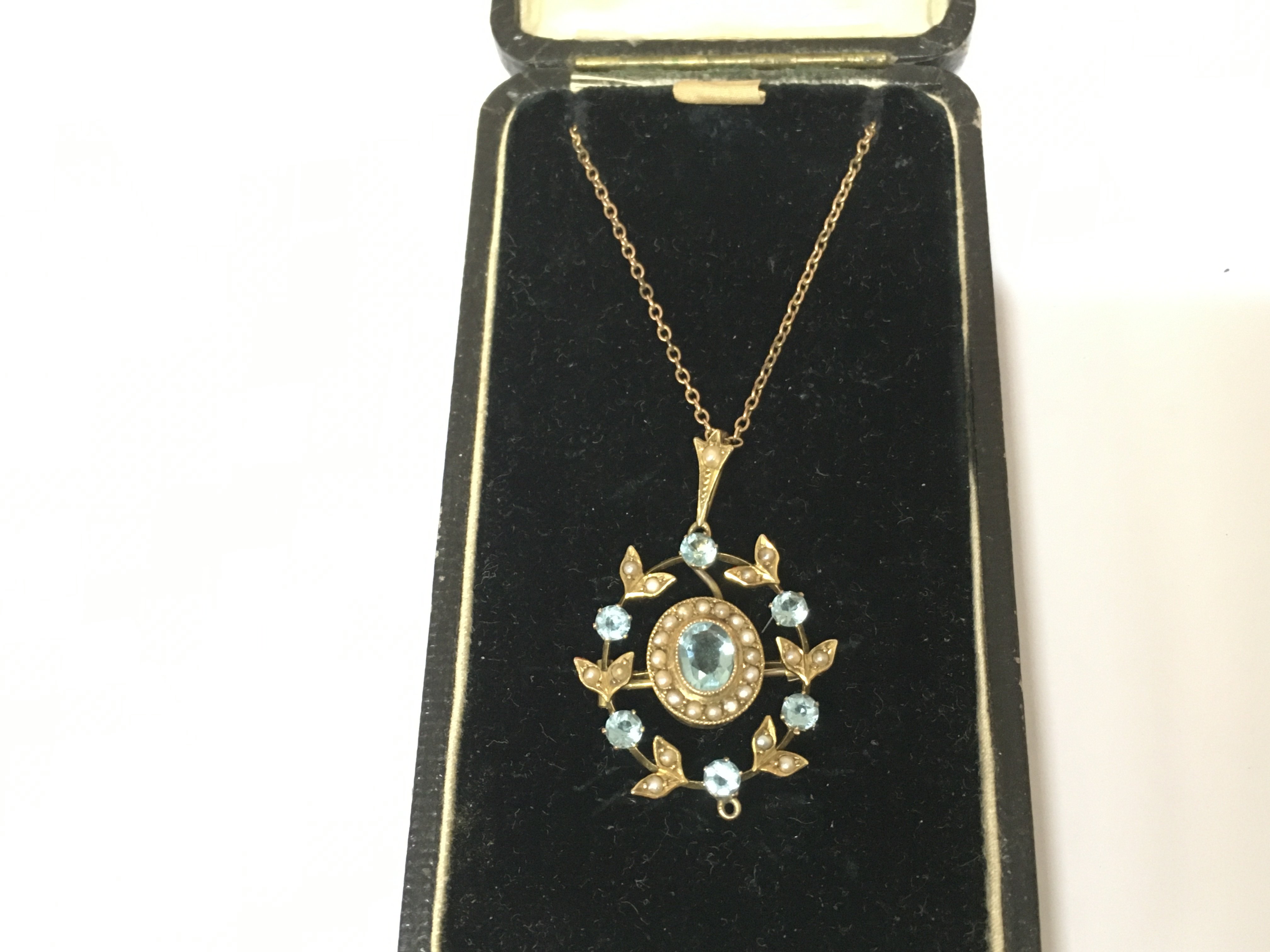 An Edwardian 9ct seed Pearl and aquamarine pendant on 9ct chain. Postage B