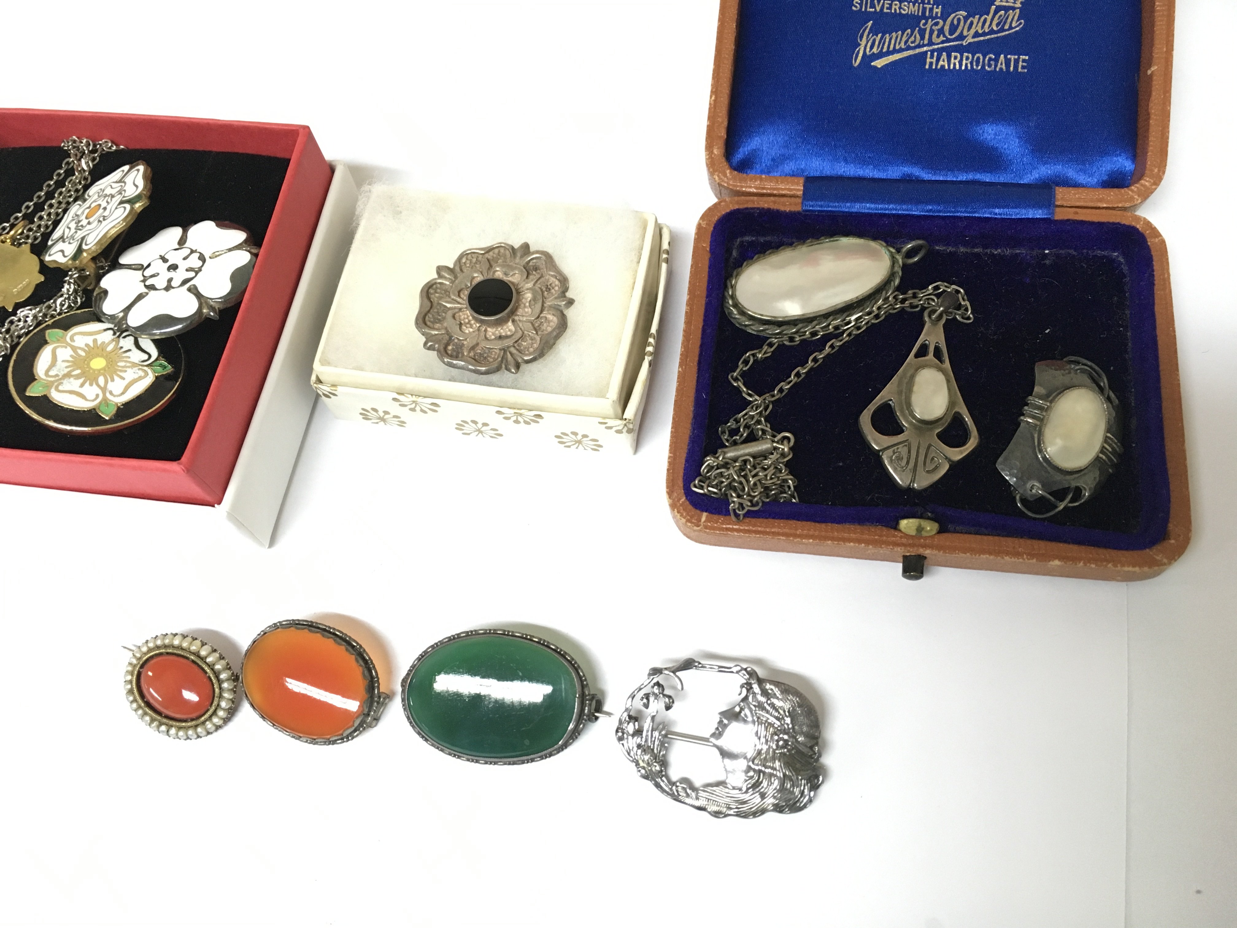 A collection of assorted silver brooches.