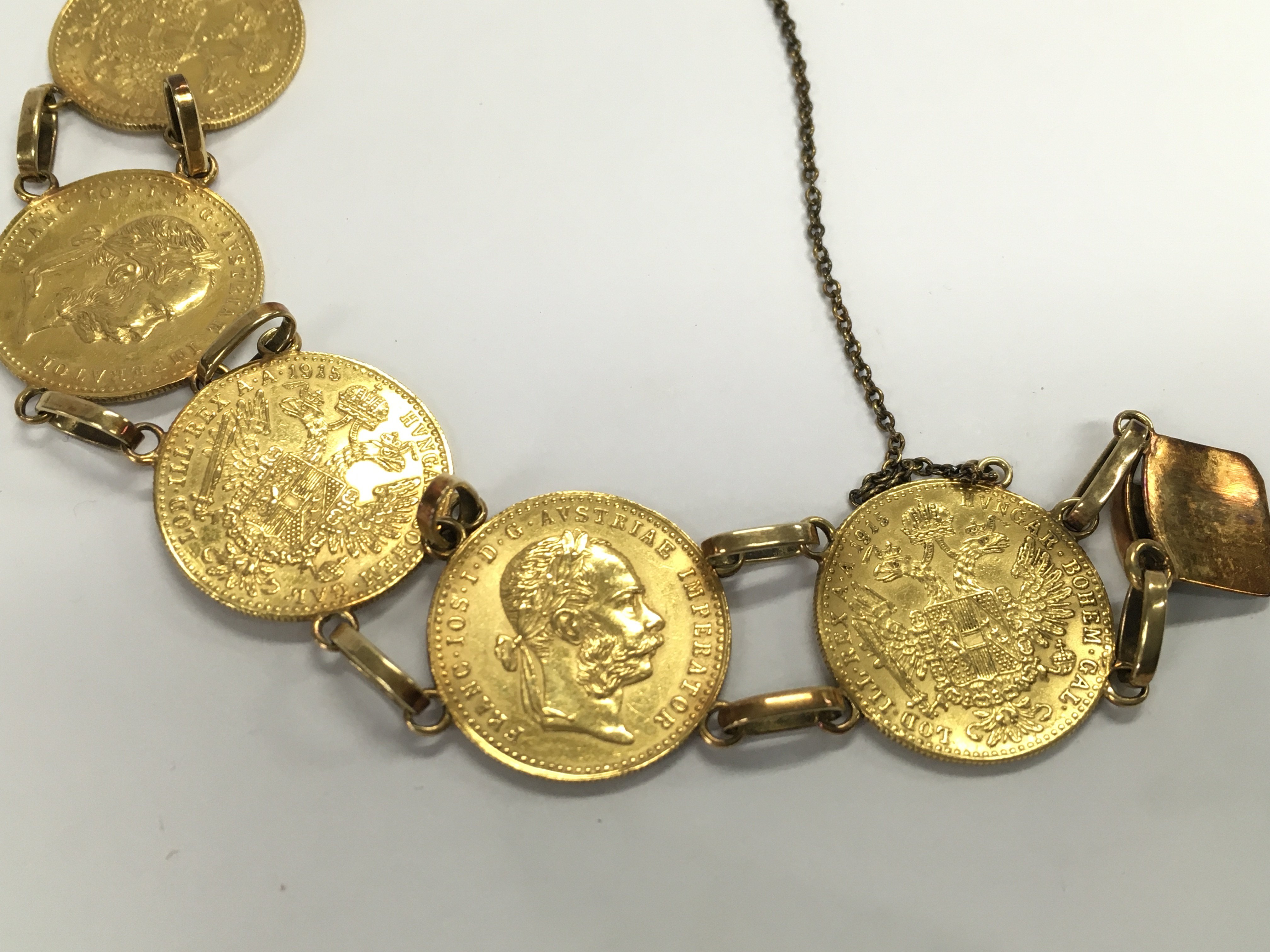 A gold bracelet made up of 7 ducat coins with 14ct links. Total weight approximately 30.75g