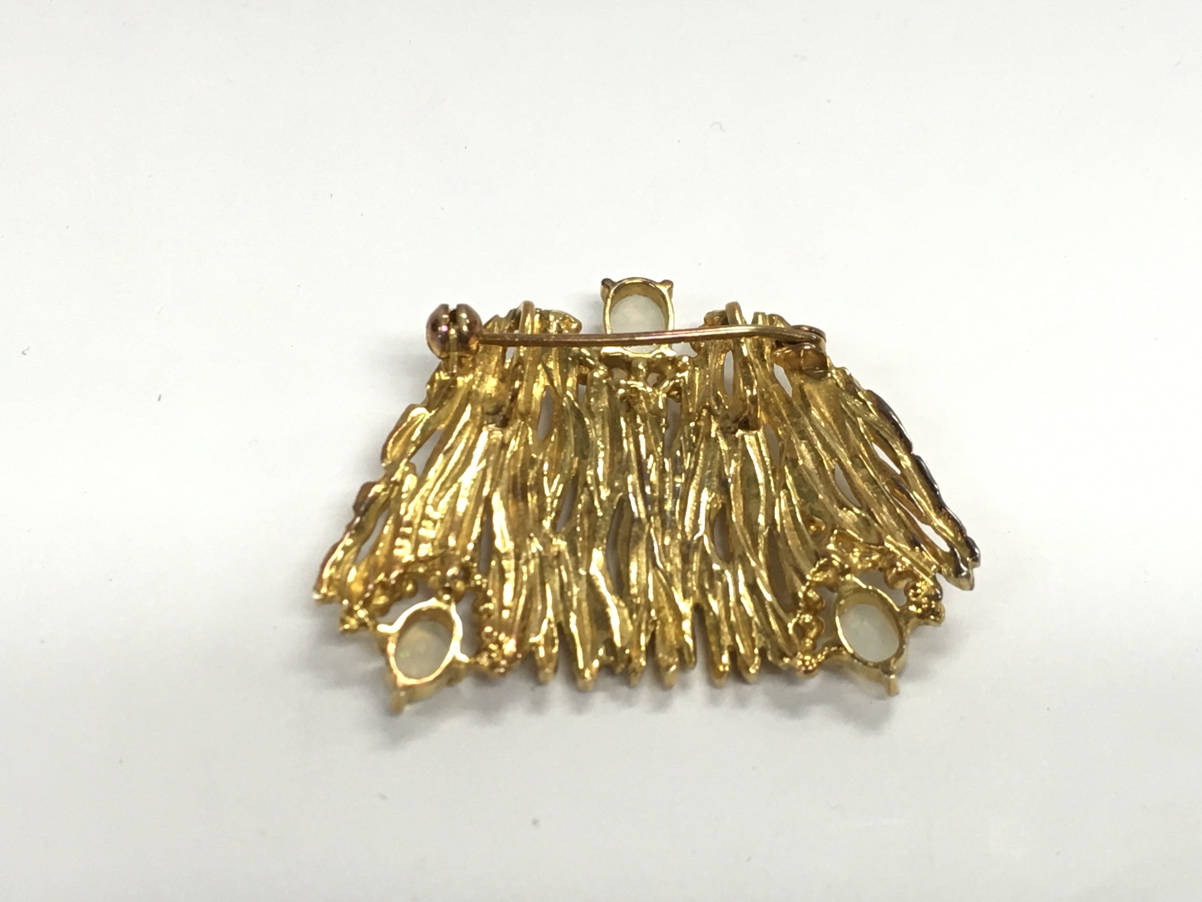An unmarked gold brooch set with three opal stones. Approximately 4cm wide and 16.20g