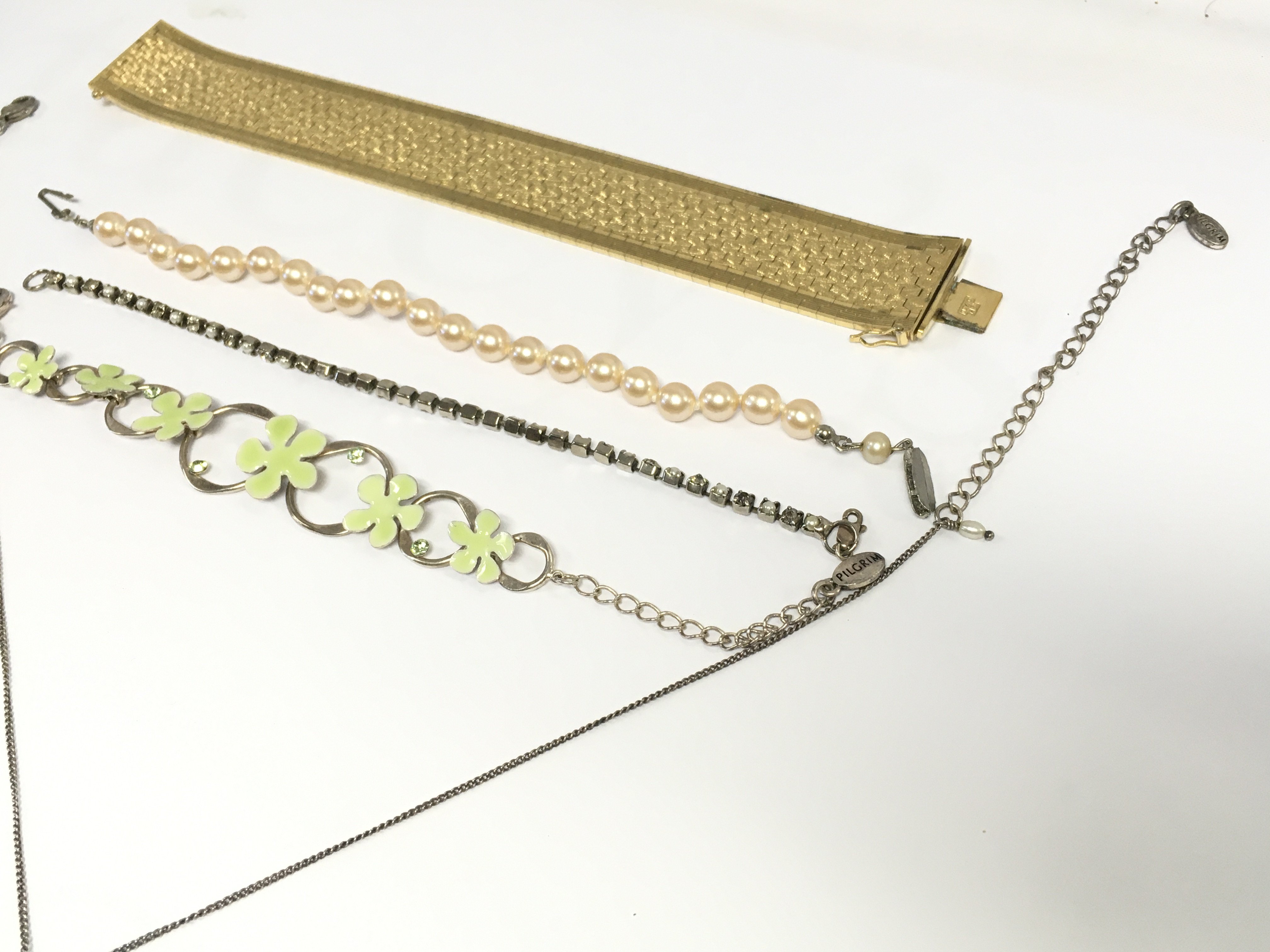 Four bracelets and a floral design necklace. Postage B. NO RESERVE