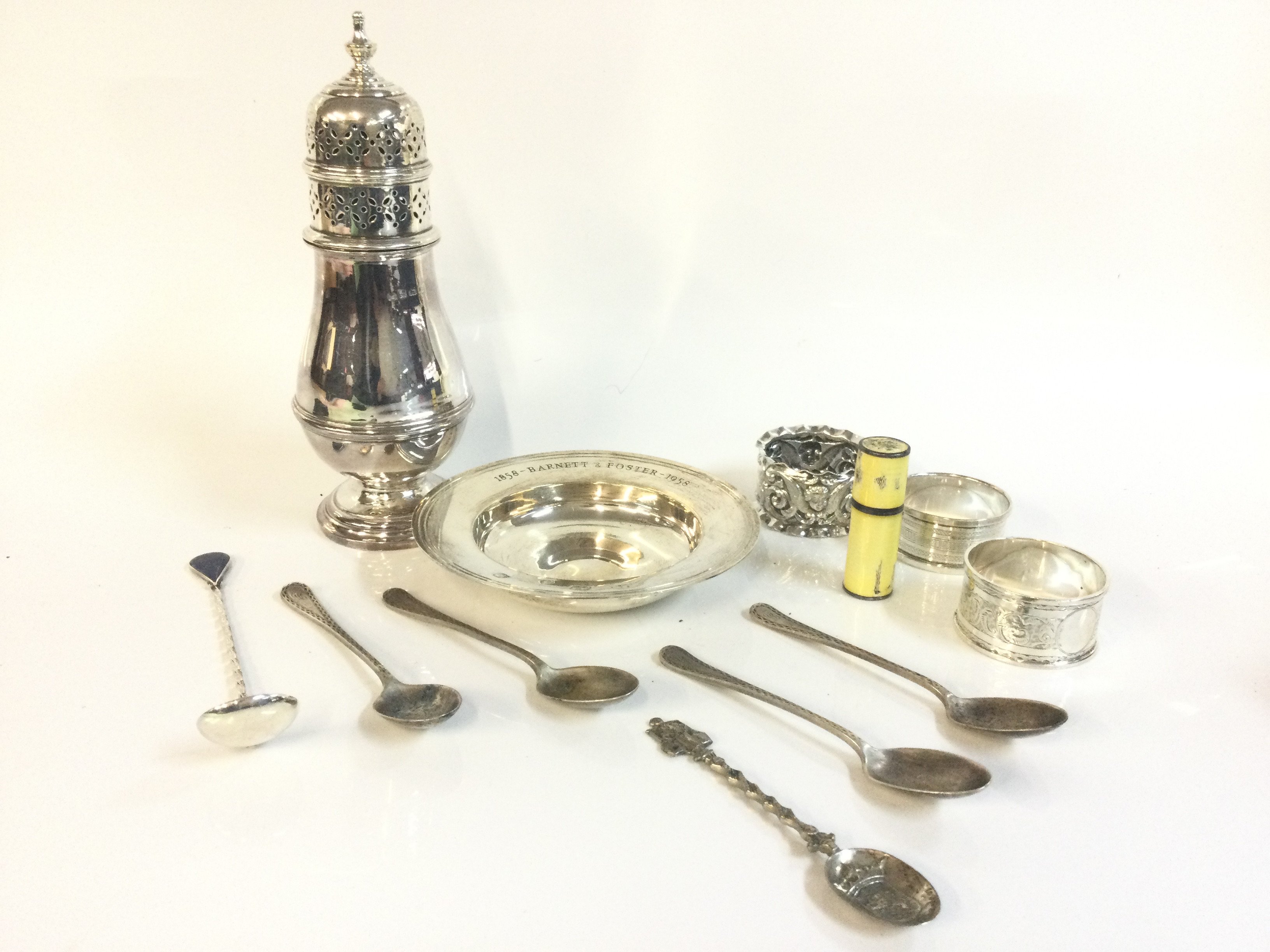 A collection of hallmarked silver items including spoons, sugar sifter , napkin rings. Postage category B