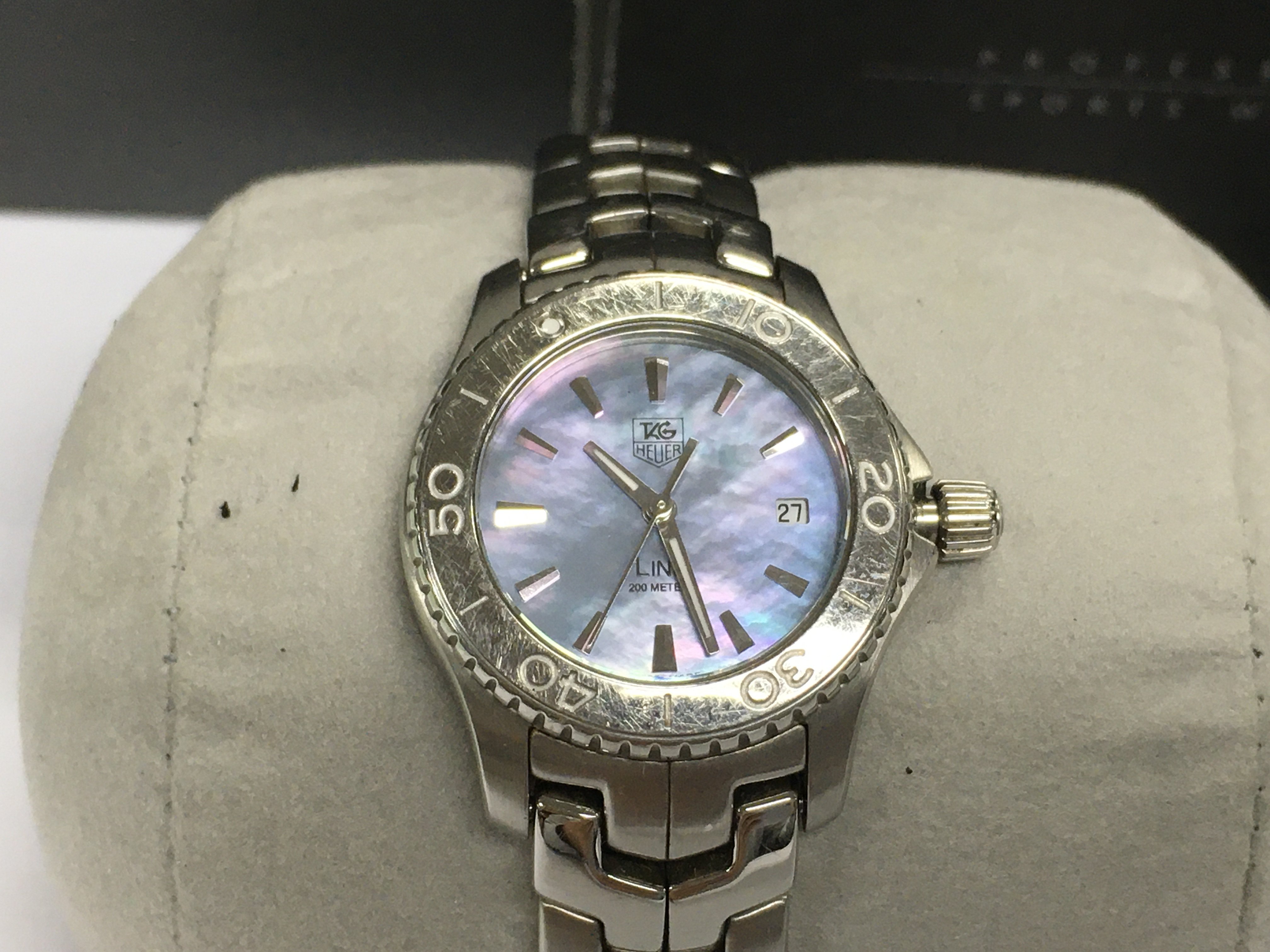 A ladies Tag Heuer link quartz watch. Stainless steel case and bracelet with a mother of Pearl dial. Comes with box and papers.