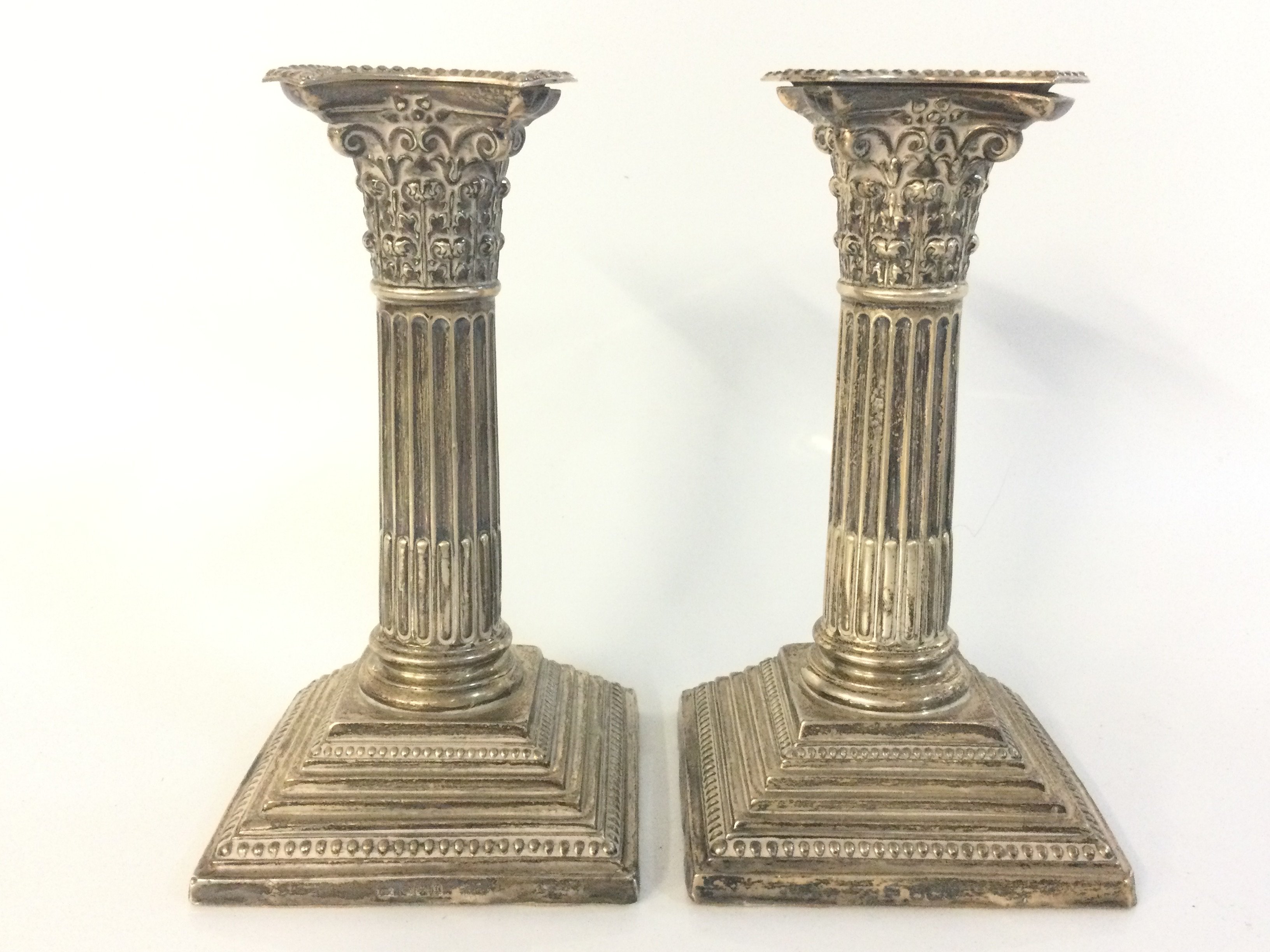 A pair of hallmarked silver Corinthian column candlesticks , 16cm tall. Postage category B