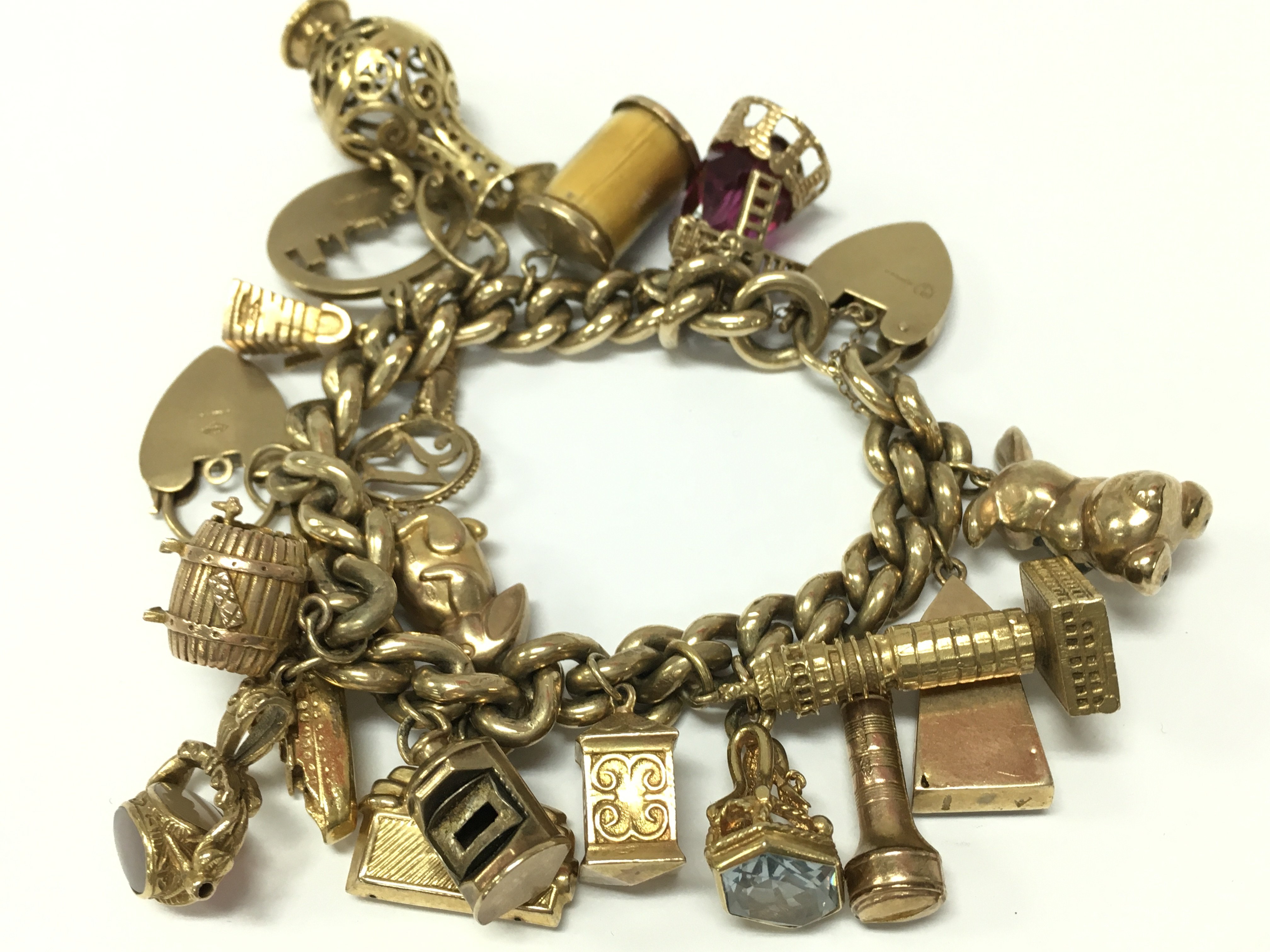 A 9ct gold charm bracelet, approximately 120g total weight. Postage category A