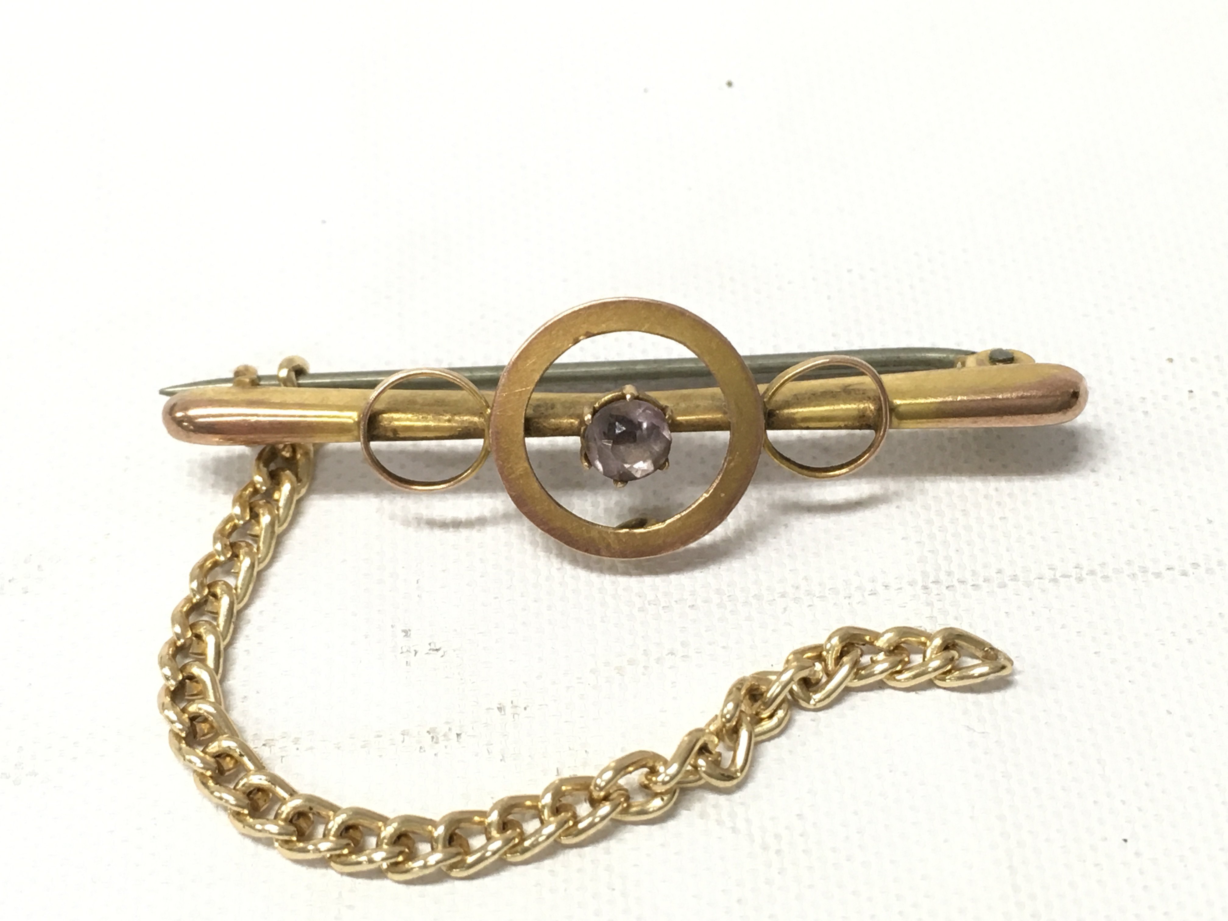 A 9ct gold brooch with a yellow metal safety chain attached. Approx weight 1.54 grams without safety chain.