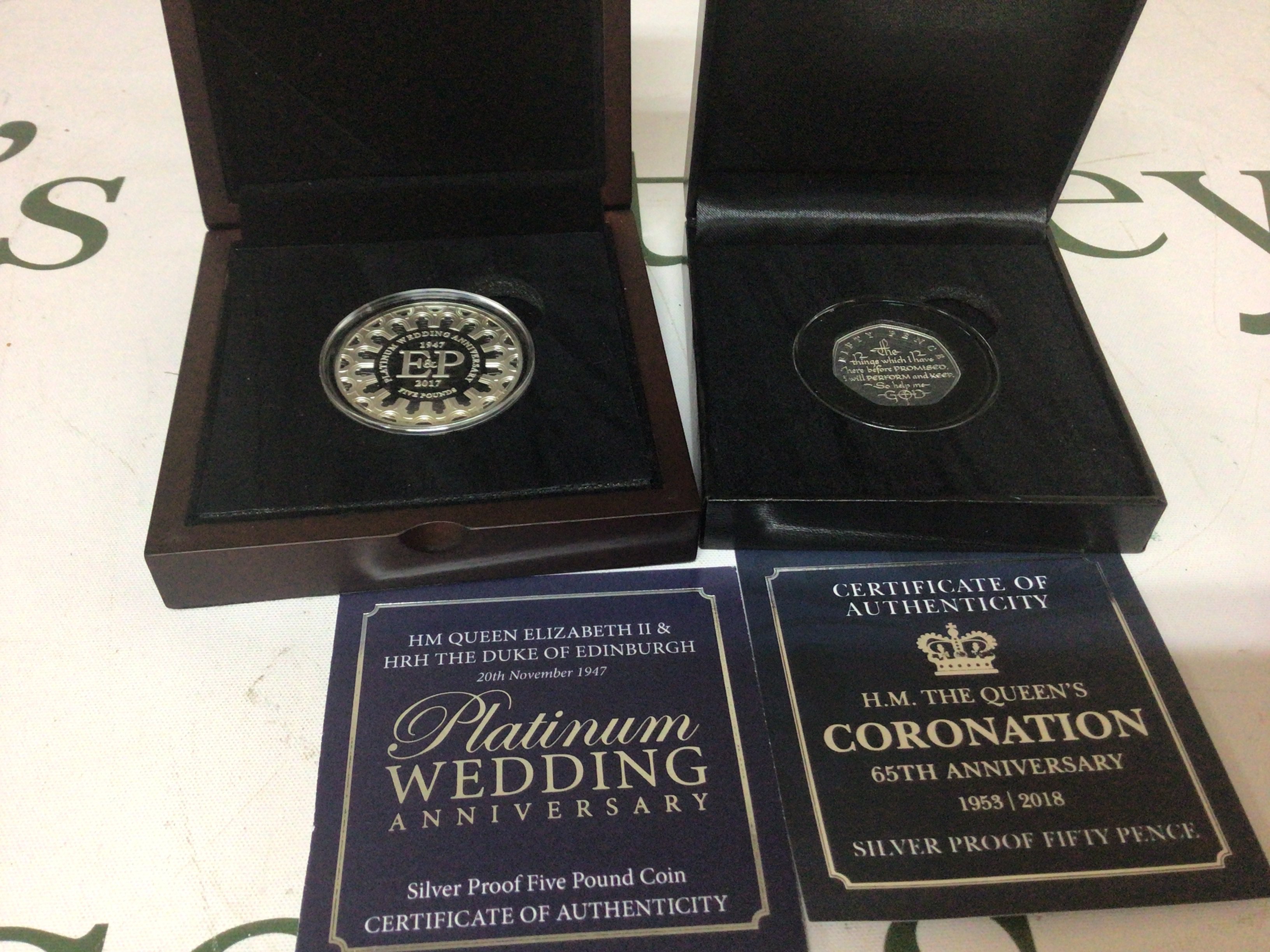 A Silver proof five pound coin The Queens platinum wedding anniversary and a silver fifty pence 65th Anniversary (2)