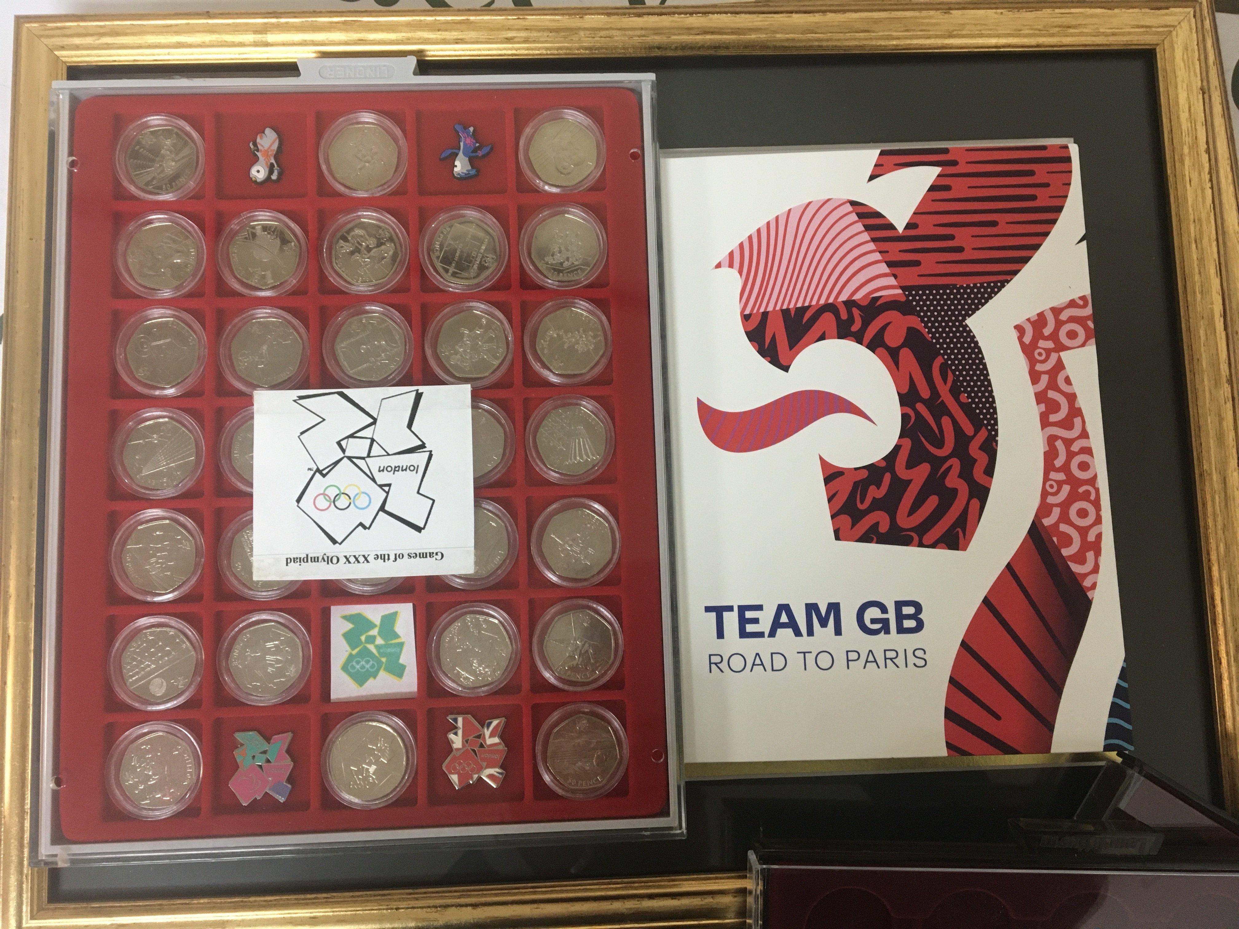 A collection of Olympic commemorative coinage Team GB road to Paris fifty pence London Olympic coins framed stamps and cases of other commemorative coins.