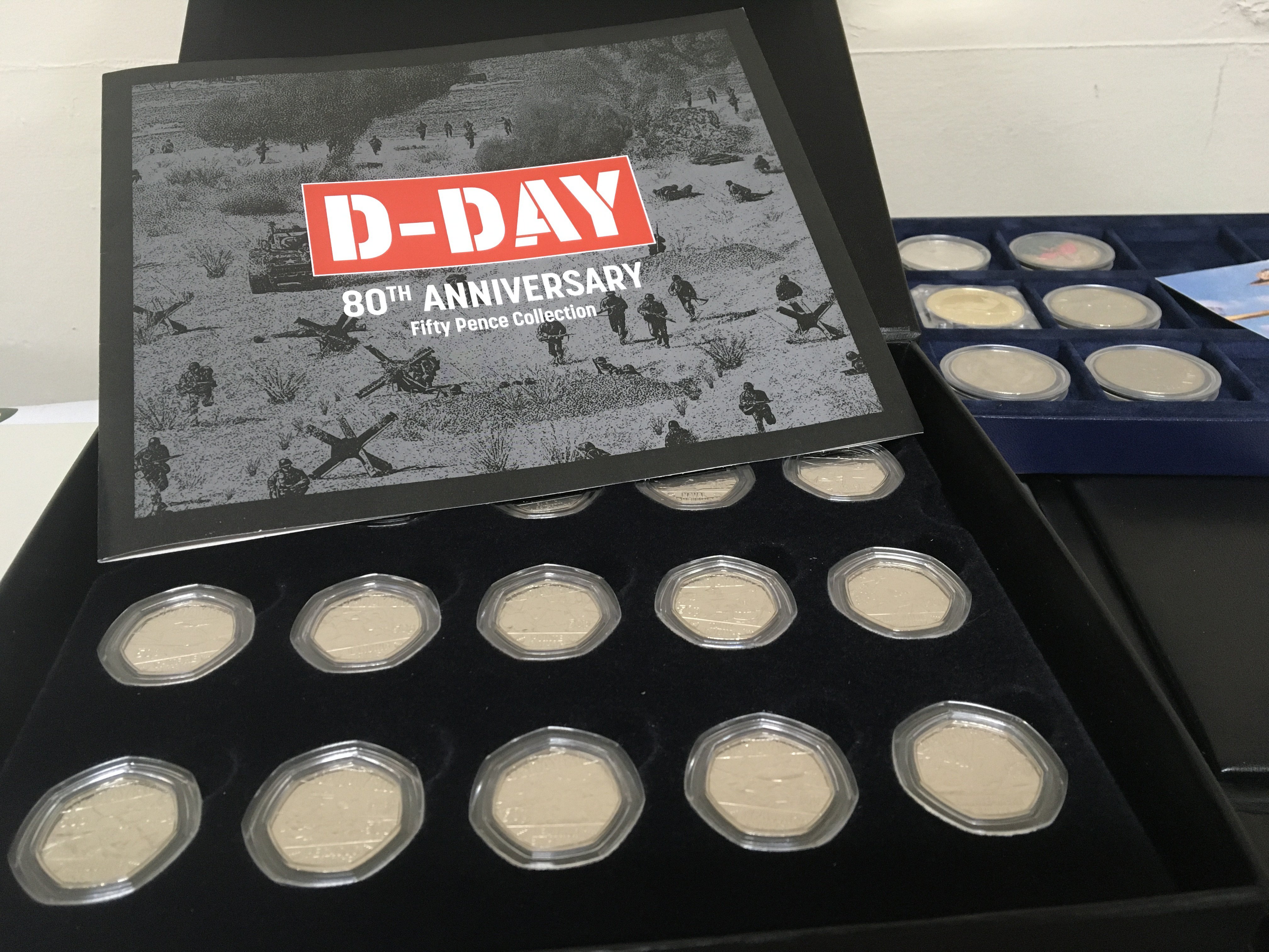 A collection of cased coins The D-Day 80th Anniversary fifty pence set my Great Britain A-Z of World War Two and a Royal Mint 2023 set. (4)