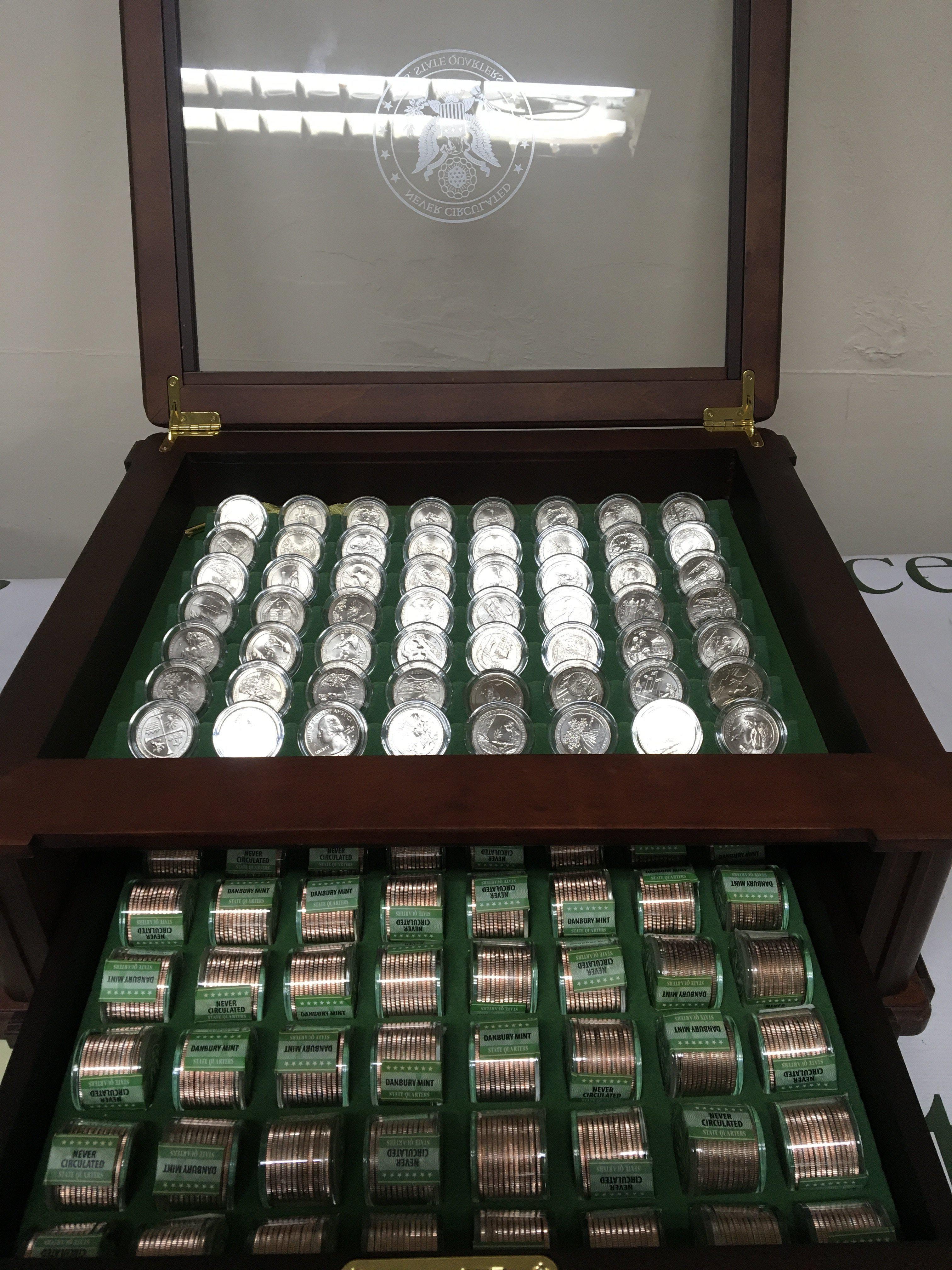 A case containing an extensive collection of never circulated State Quarters in sealed packs of twelve and a state set of 2020 American Quarter dollars all in a well presented cabinet and complete.