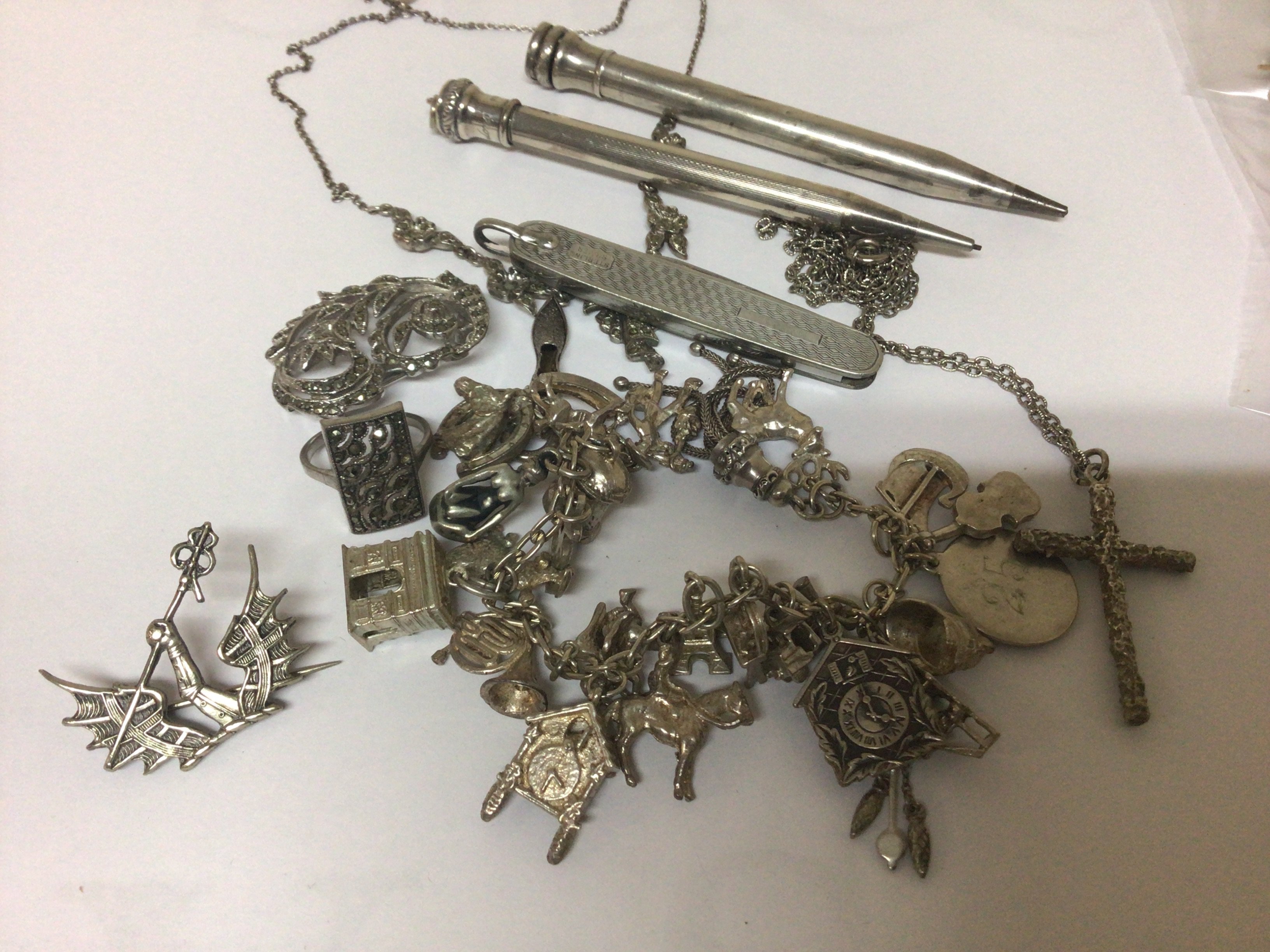 A Silver charm bracelet and other silver jewellery pens and other ornaments.