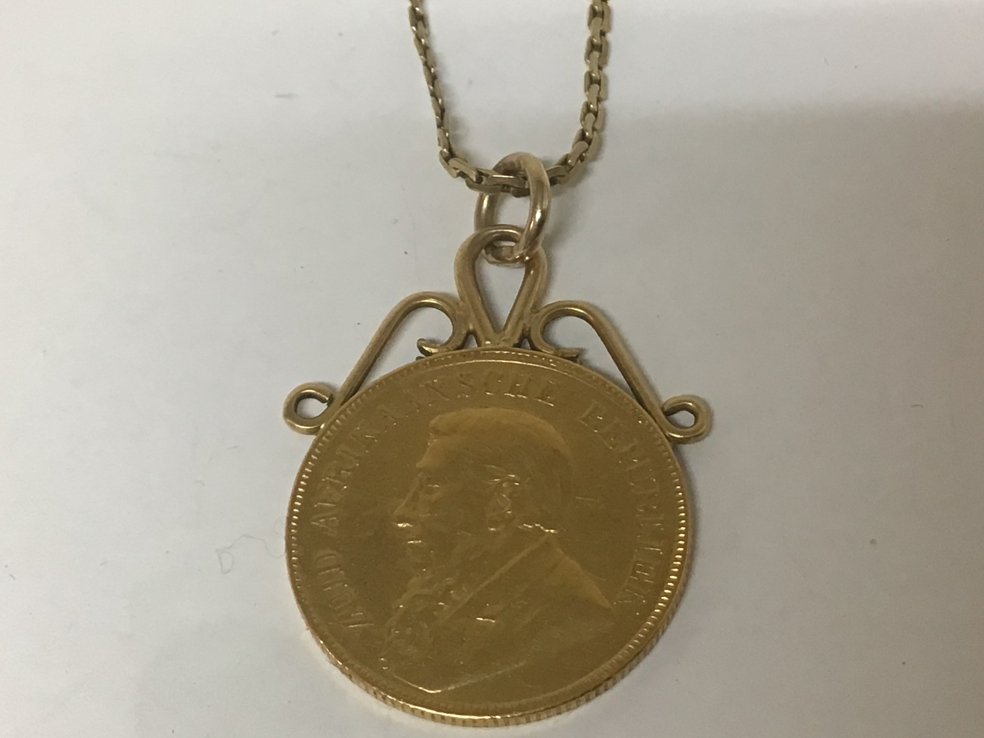 A Gold South African one pound coin 1897 on a pendent mount with attached 9Carat gold chain. Total weight 12.5g