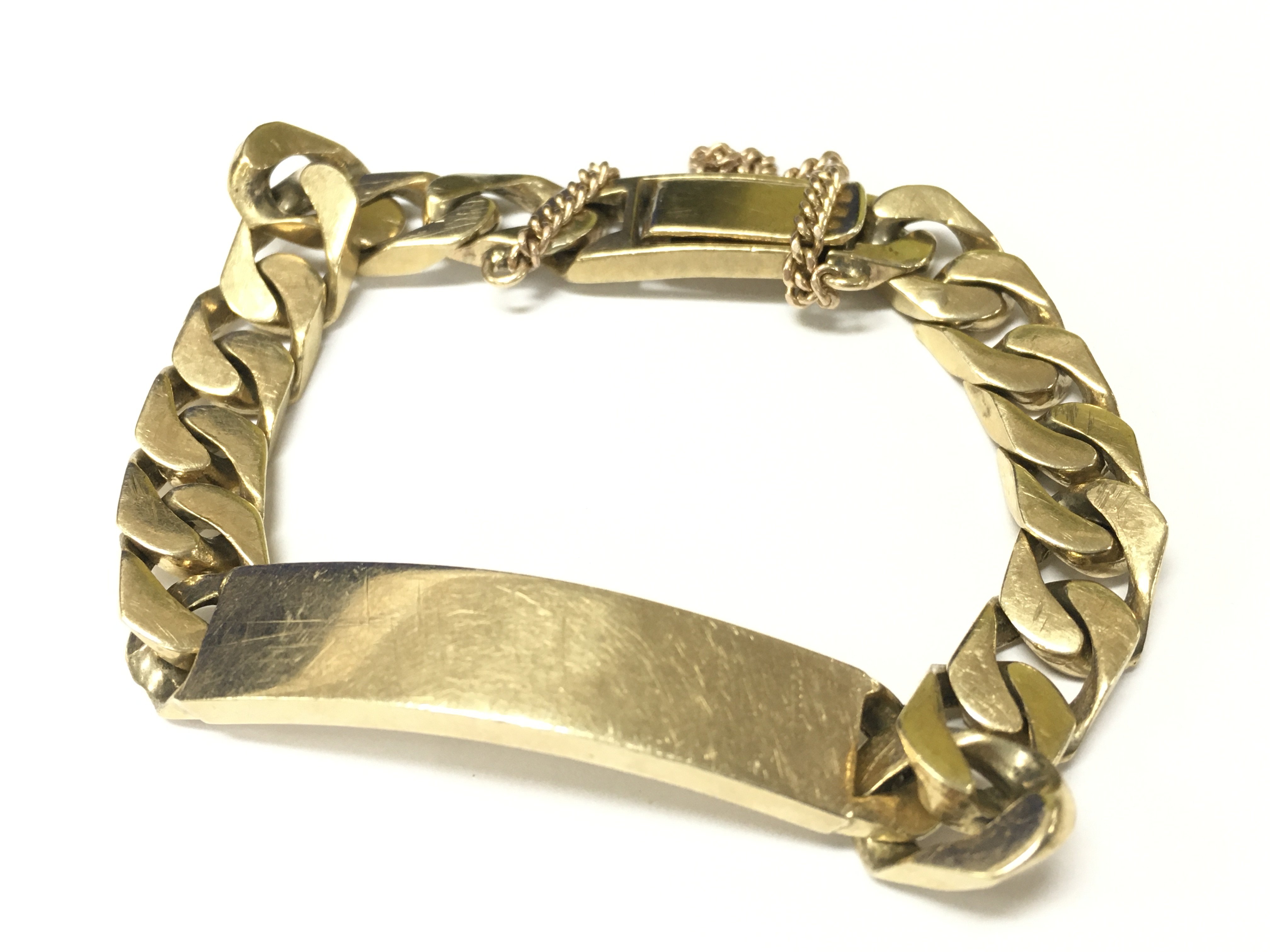 A 9ct gold heavy I.D bracelet with safety chain. Appox weight 61.43 grams.