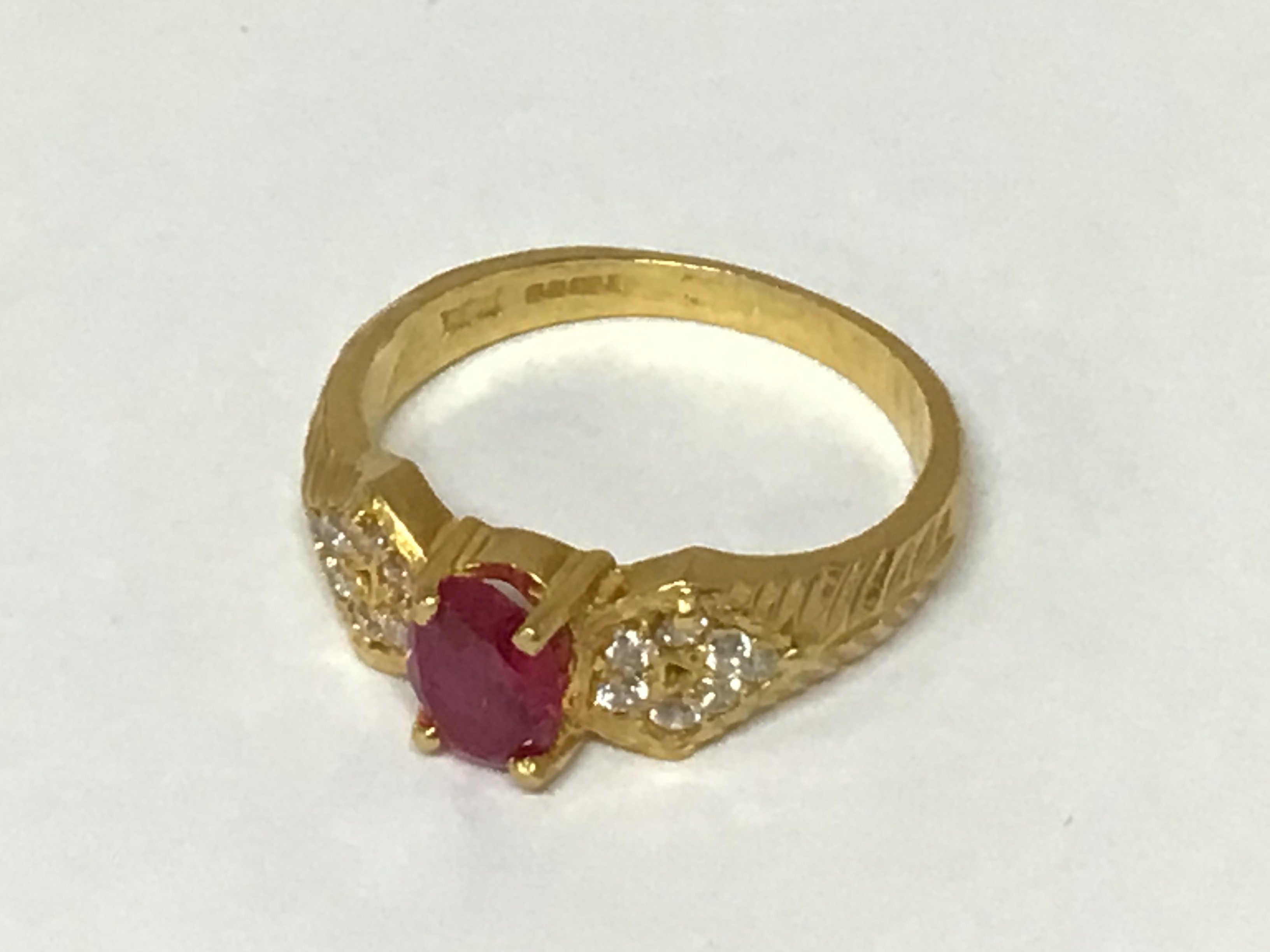 A Quality 22carat gold ring set with a ruby flanked by small diamonds weight 5.4g approximately ring size O.