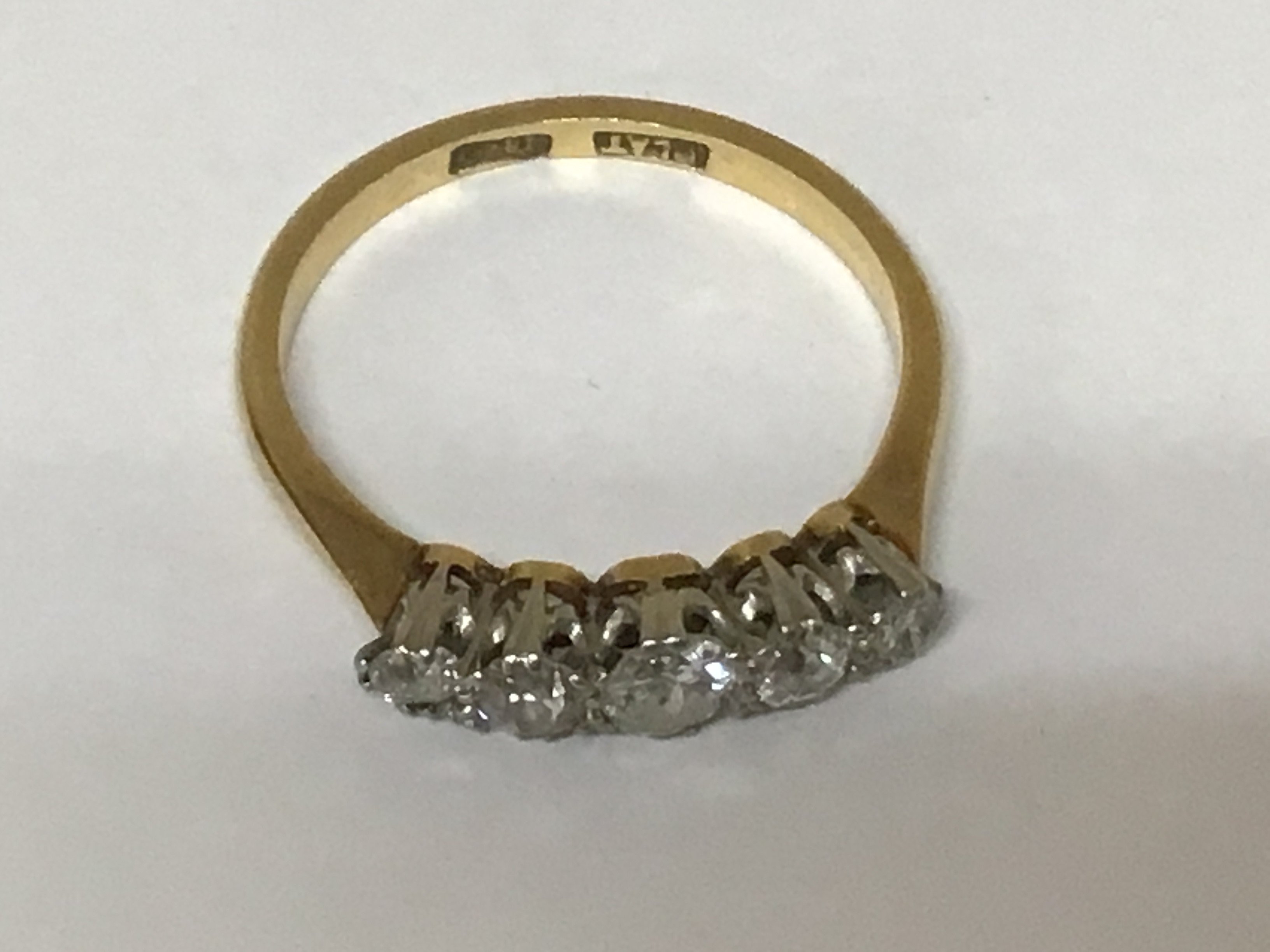 An 18carat gold ring set with a graduating row of five old cut diamonds ring size M weight 2.5g