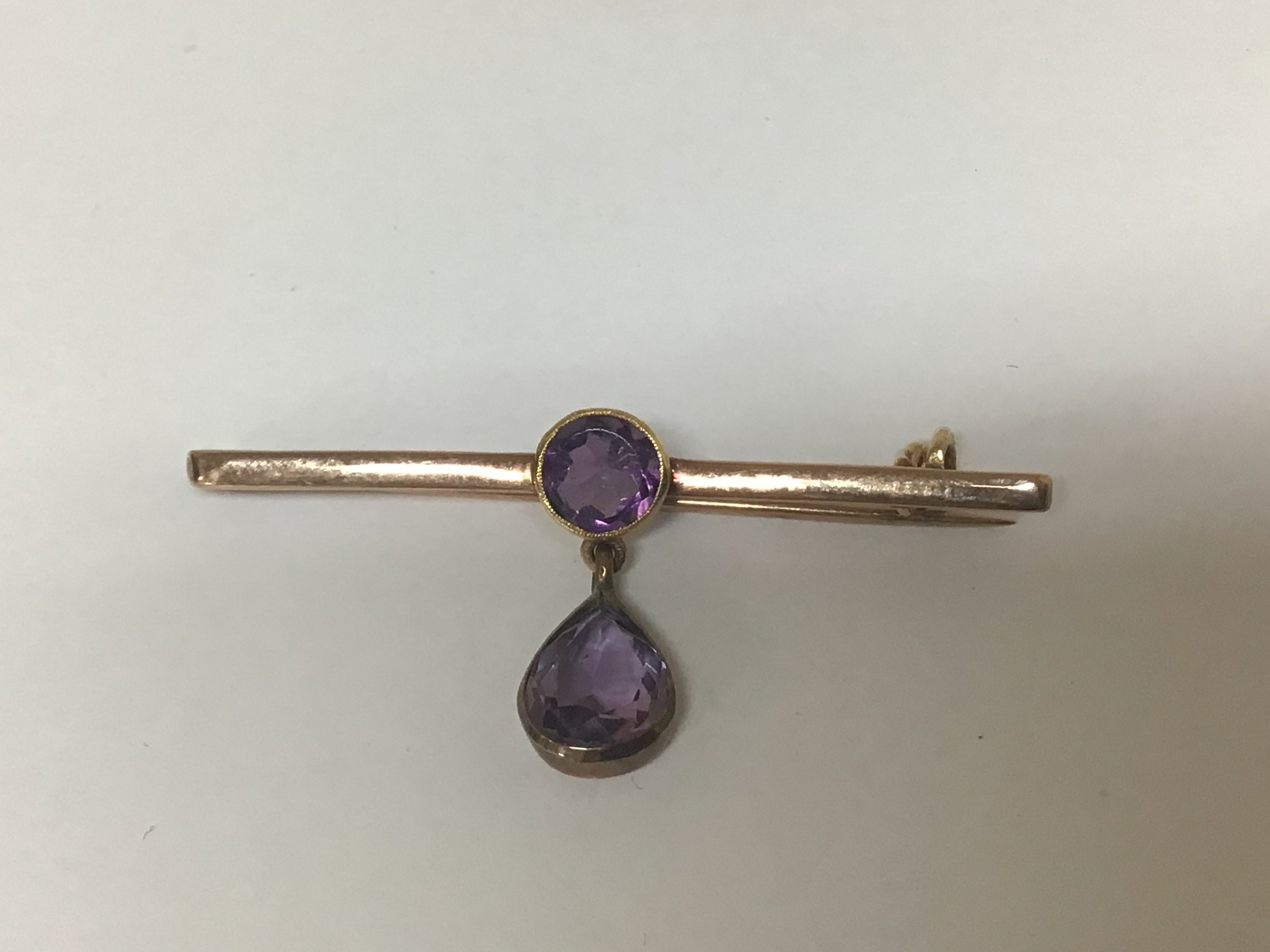 An unmarked brooch set with two Amethyst stones weight 3g