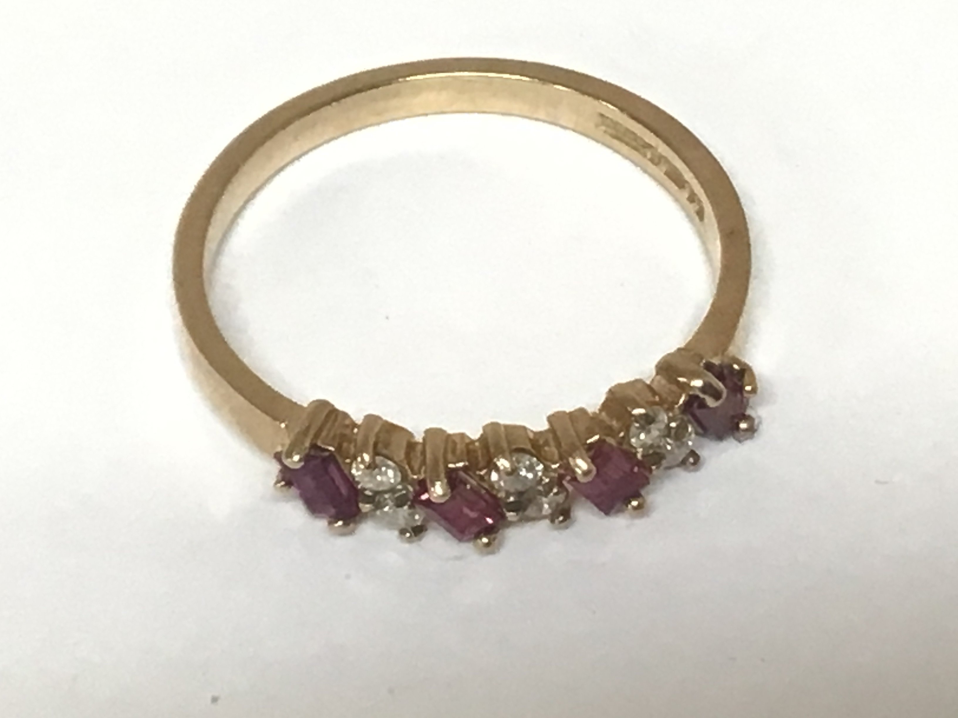 A 9carat gold ring set with alternating rows of baguette ruby and small brilliant cut diamonds.ring size P weight 2g