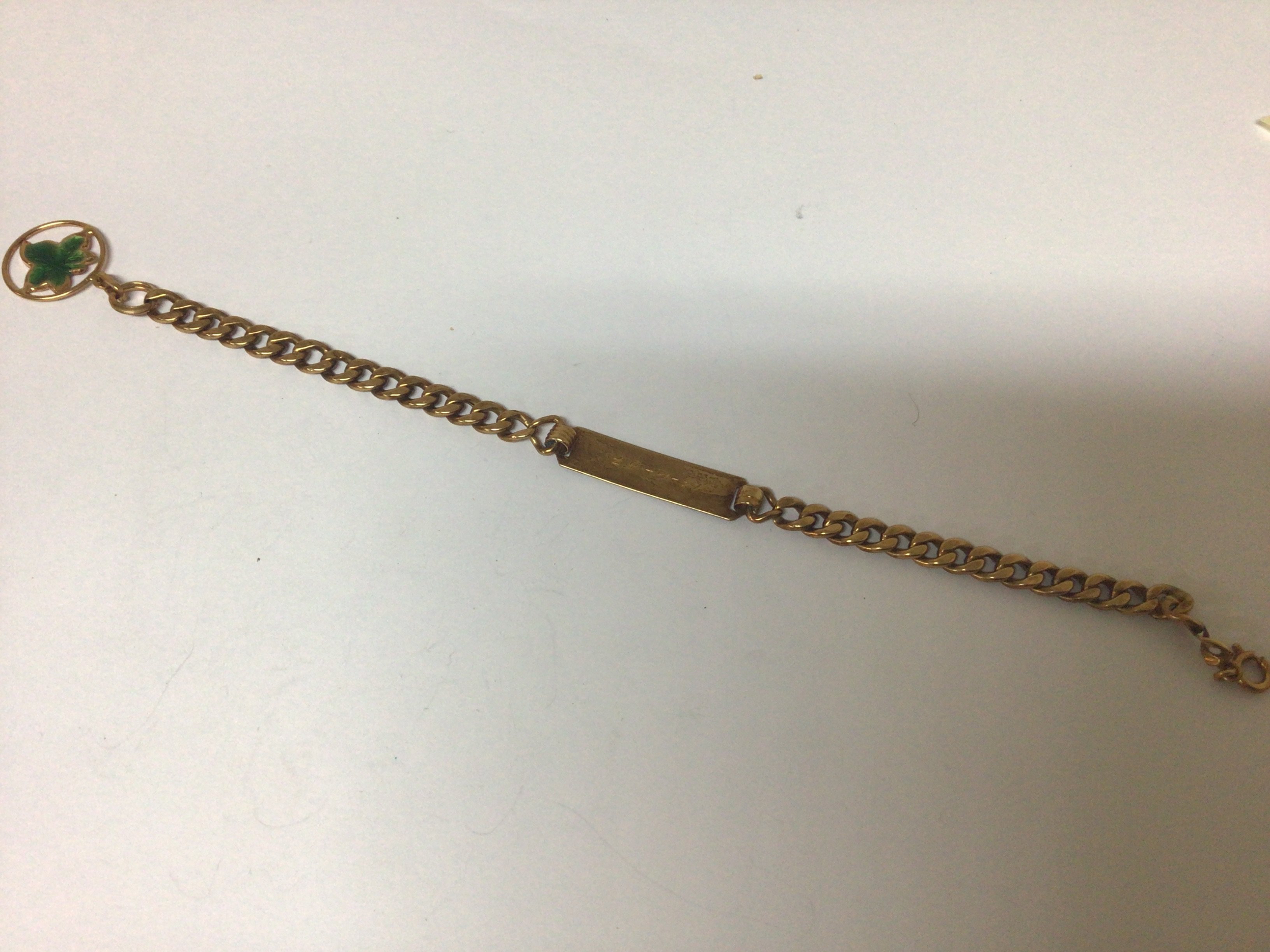 A gold ID bracelet possibly 18carat gold the attached enamel charm marked 750 sold as seen buyer to satisfy themselves before they bid. Weight 7g