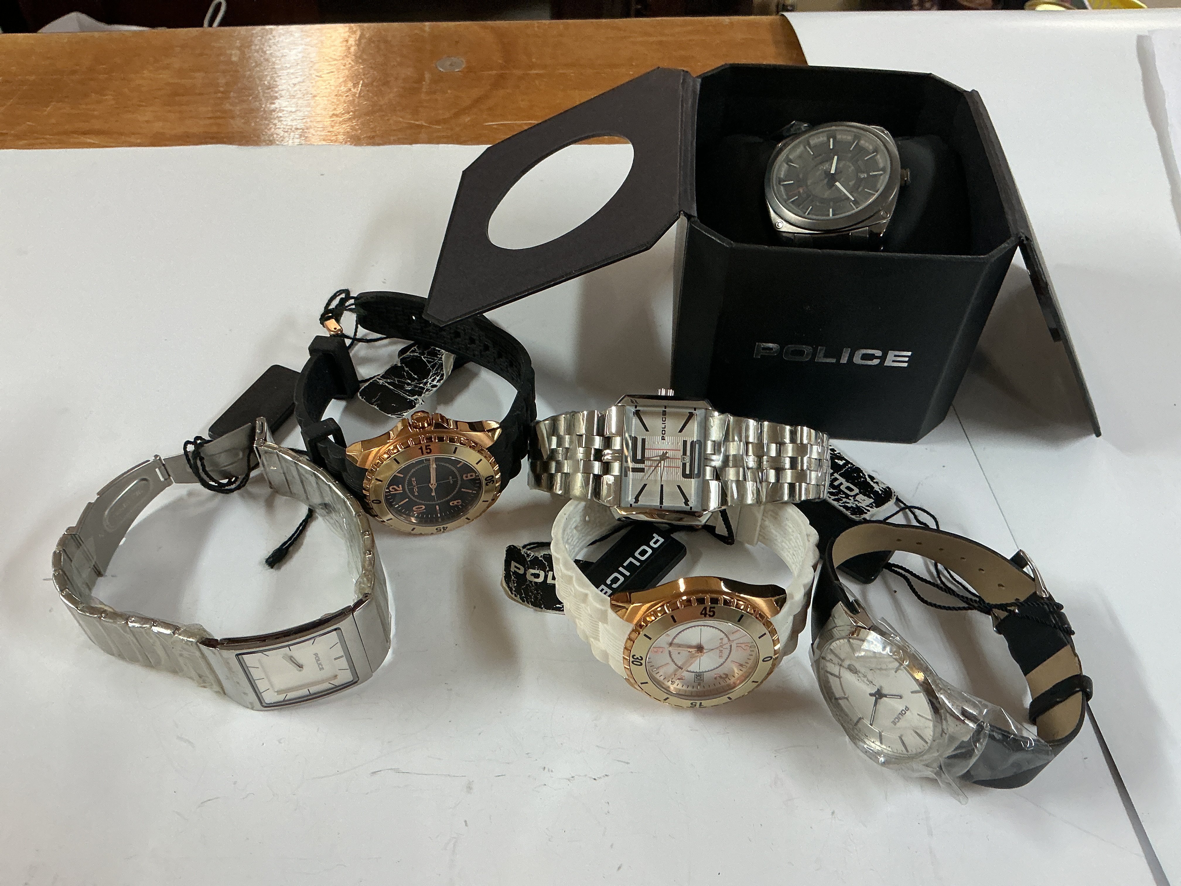 five police watches with tags and one boxed.